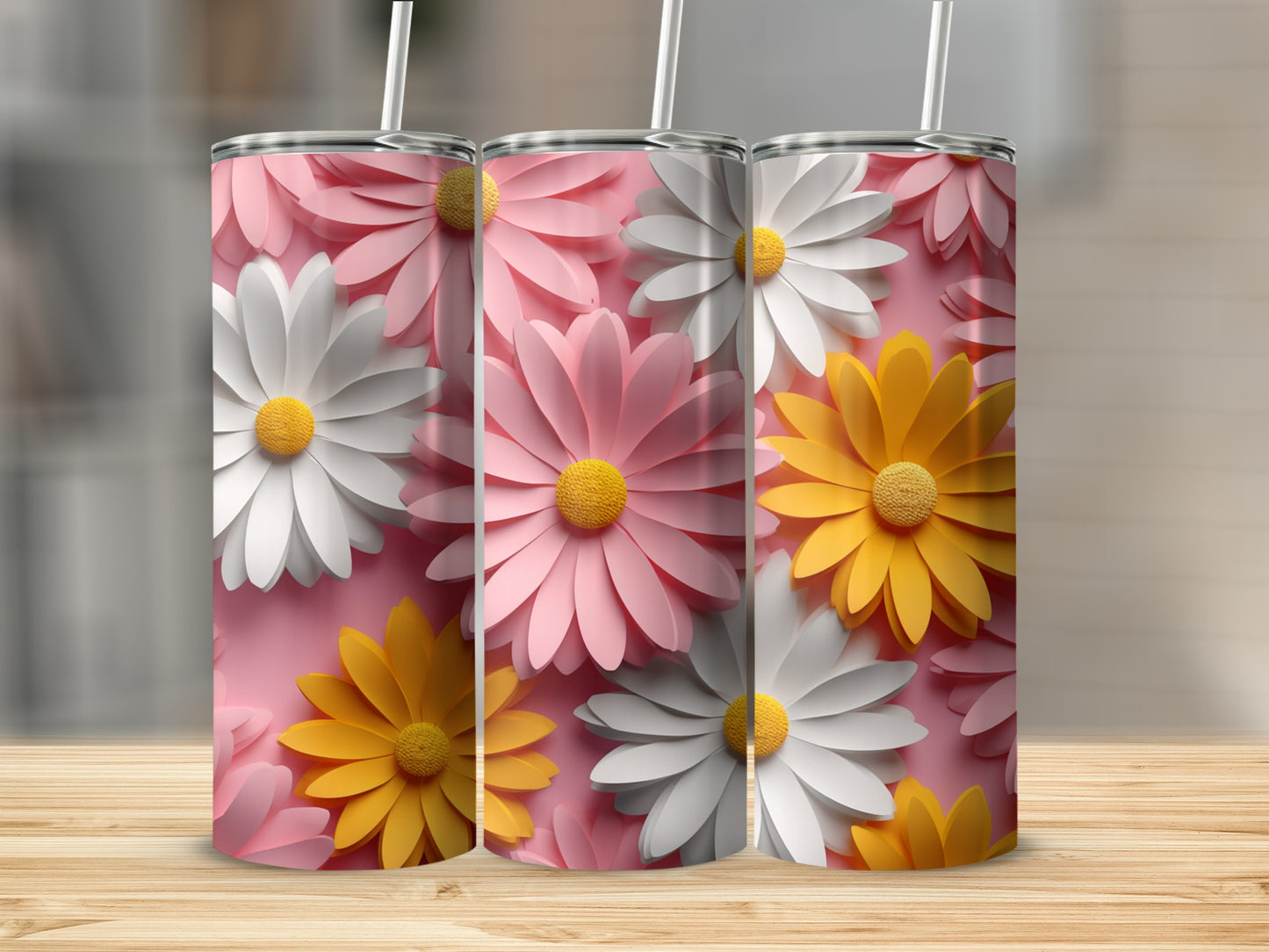 Three tumblers with floral designs in pink, white, and yellow on a pink background.
