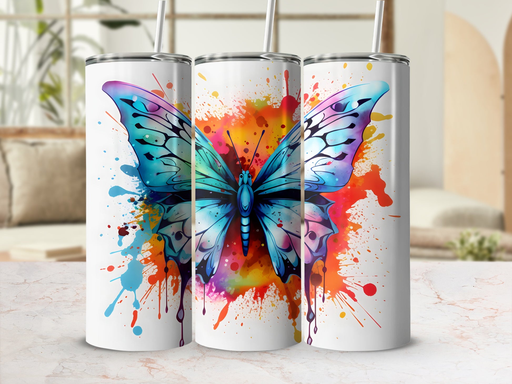 Three white tumblers featuring a blue butterfly with colorful paint splatters.