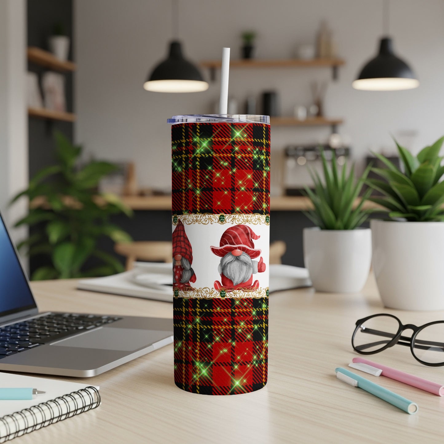 Tartan gnome tumbler with straw on desk with laptop and pens.