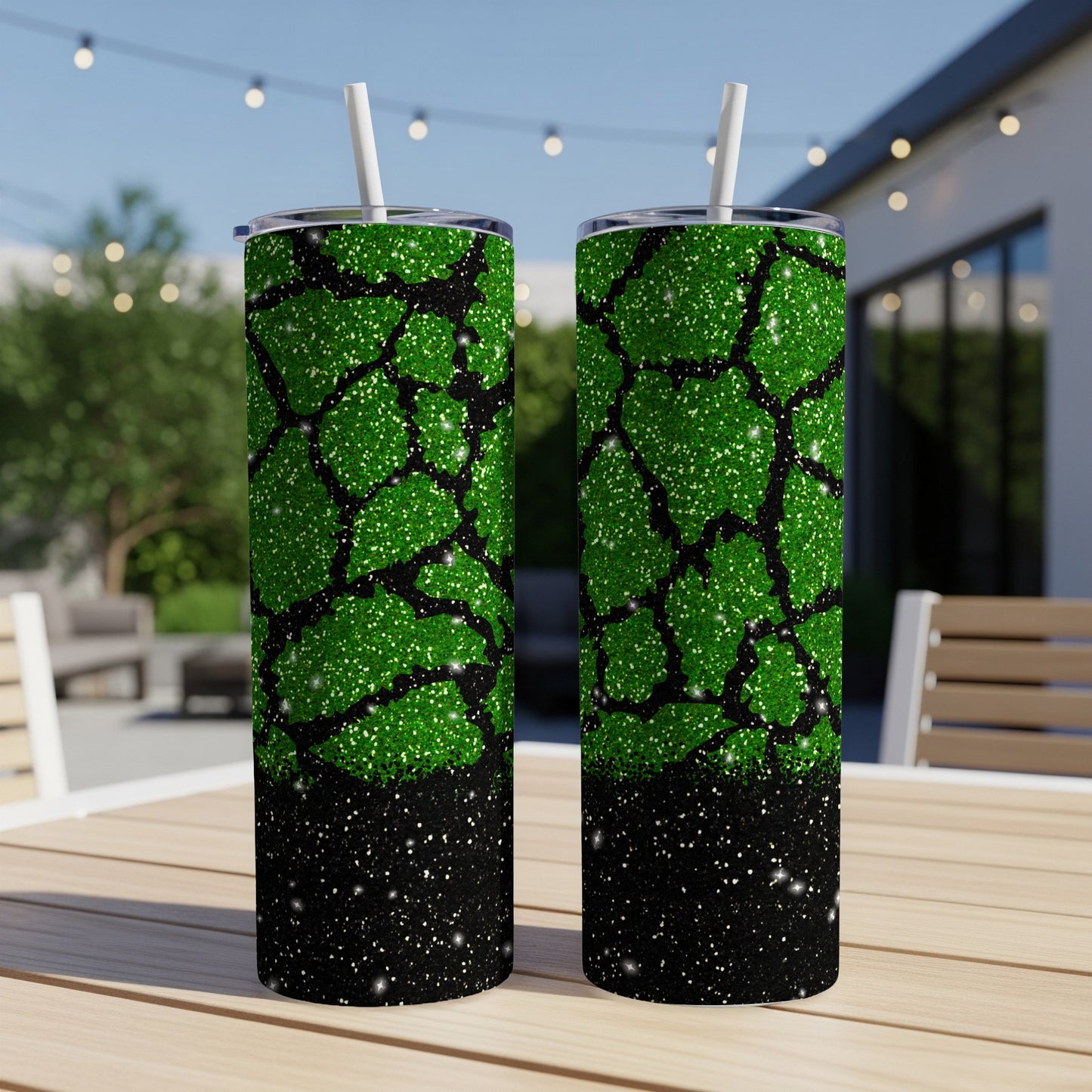 Two green glitter tumblers with black speckled accents on a table outdoors.