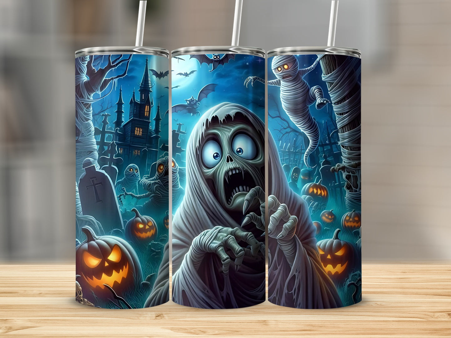 Three tumblers with a spooky Halloween graveyard scene and glowing jack-o'-lanterns.