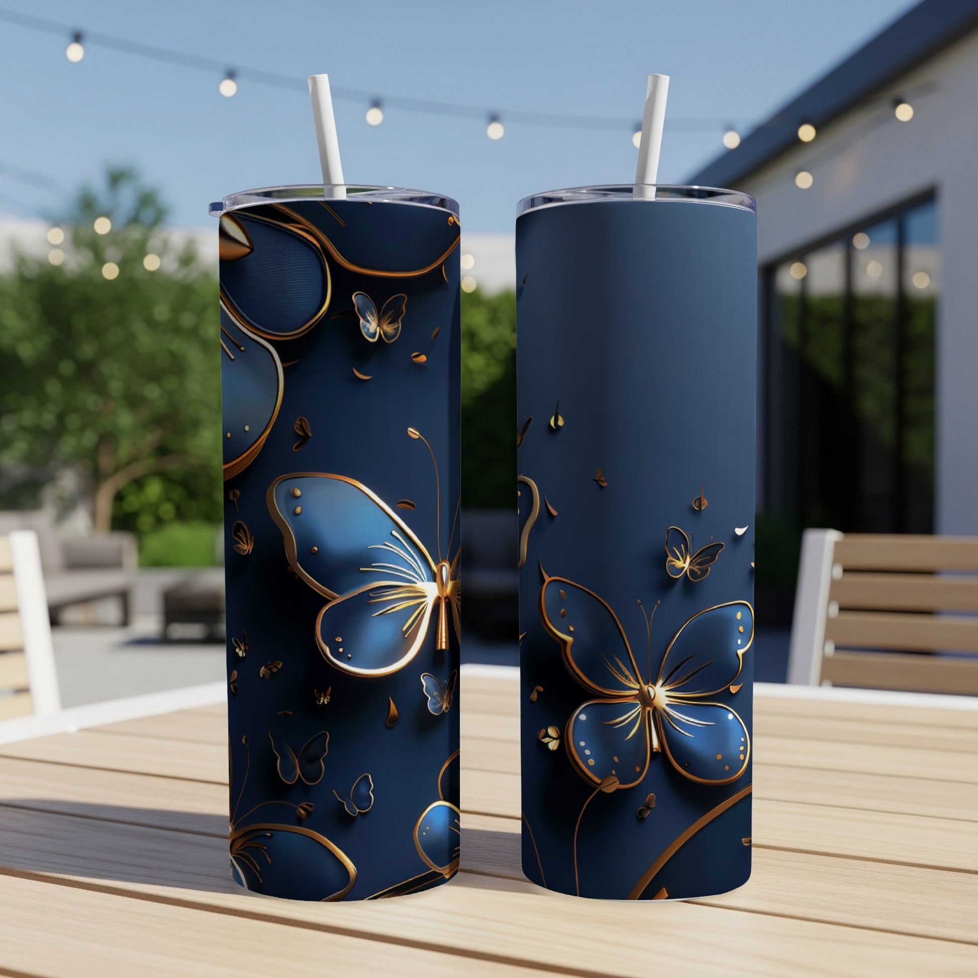 Two navy blue tumblers with gold butterfly designs sit on a wooden table.