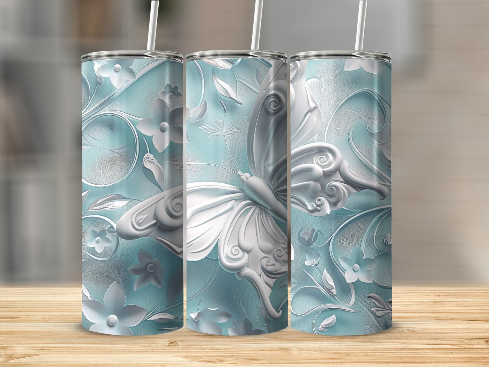 Three light blue tumblers with intricate white butterfly and floral embossed designs.