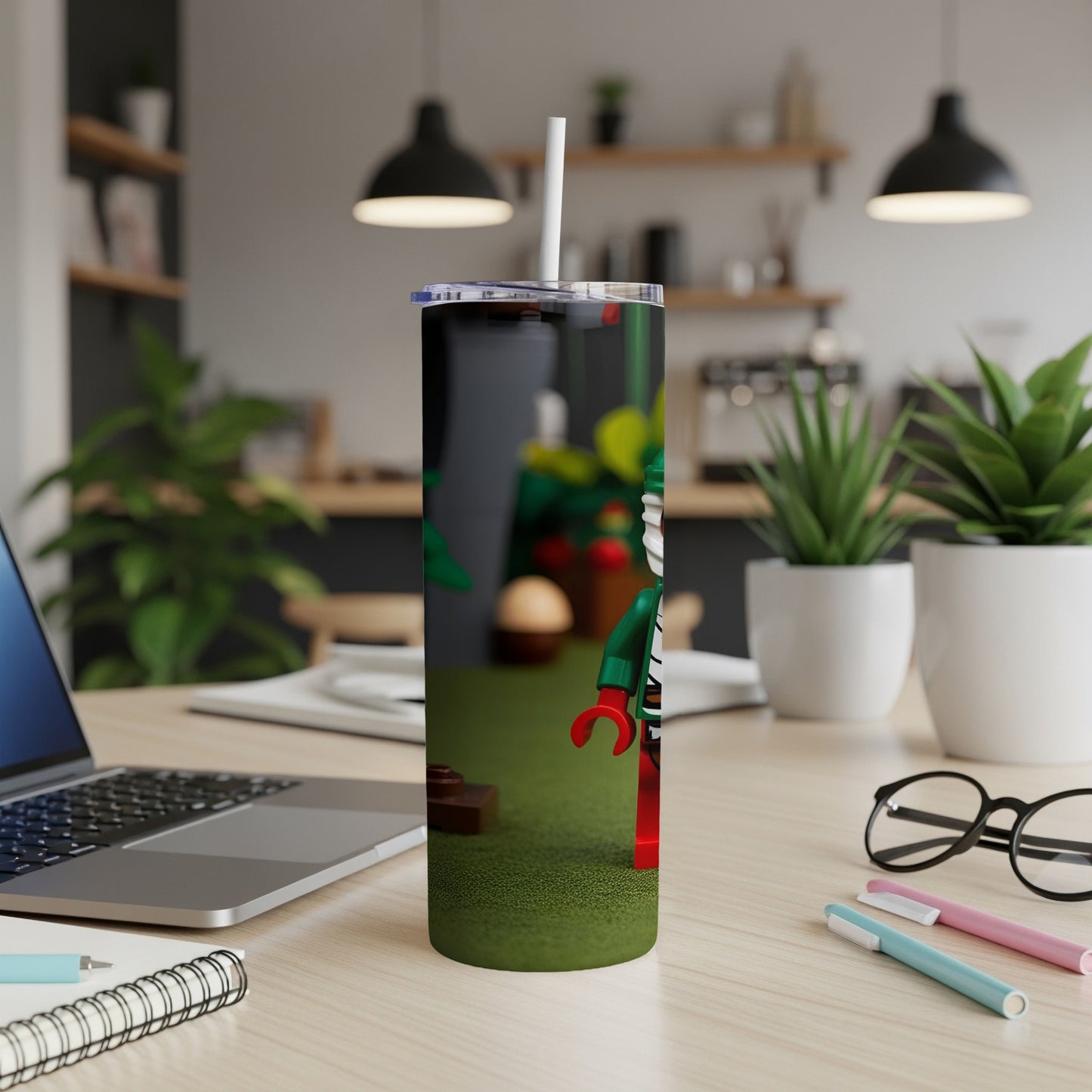 Slim tumbler with Lego minifigure, green grass, and a desk background.