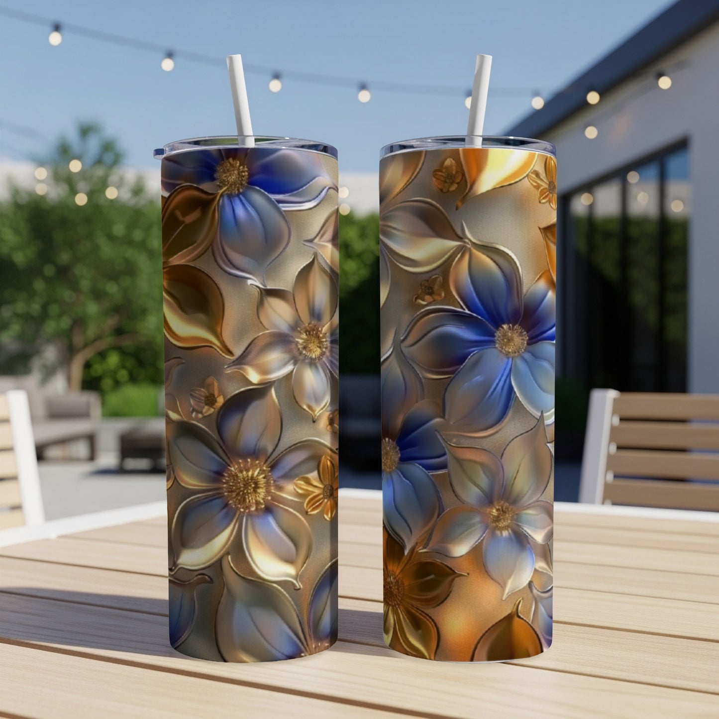Two tall tumblers with metallic floral designs on a table.