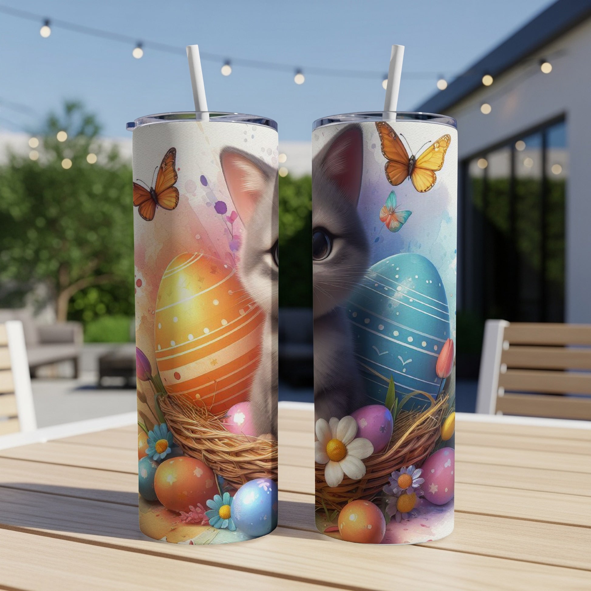 Two Easter-themed tumblers with cats and colorful eggs on a table outdoors.