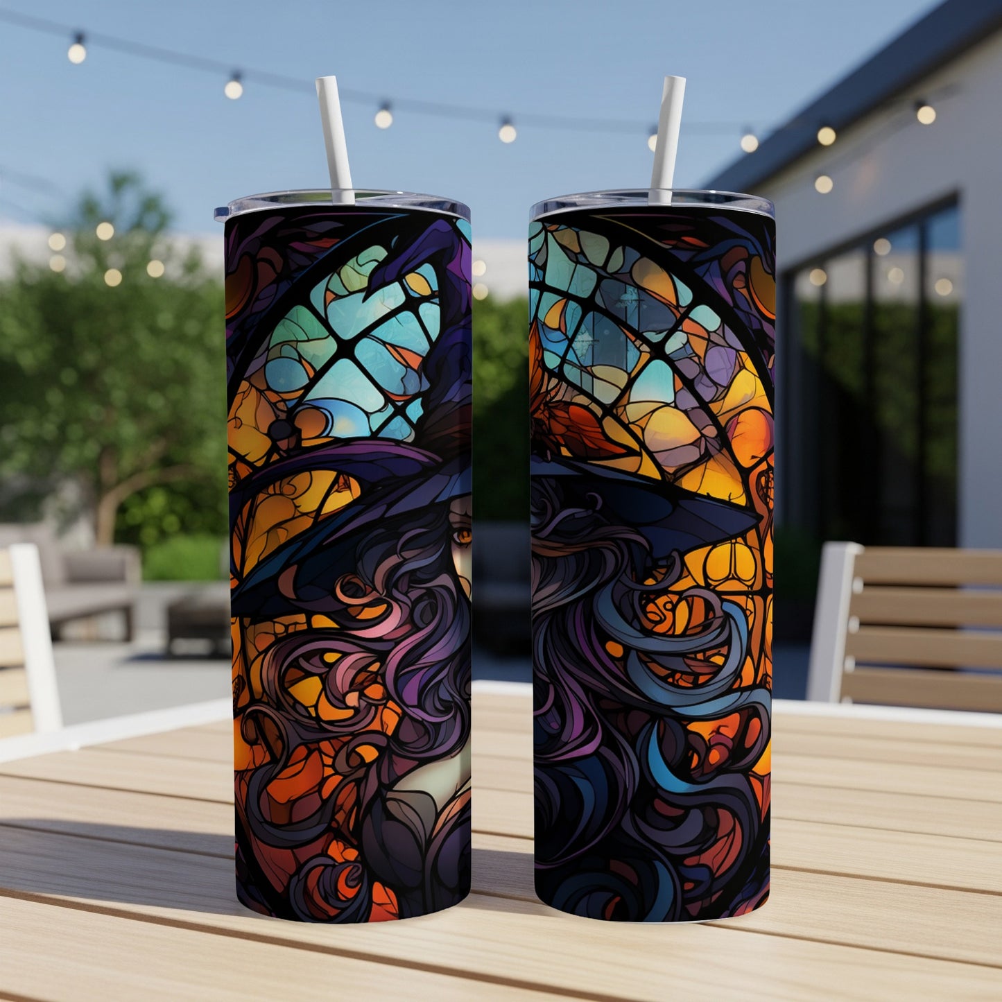 Two tumblers with stained glass witch design on outdoor table.