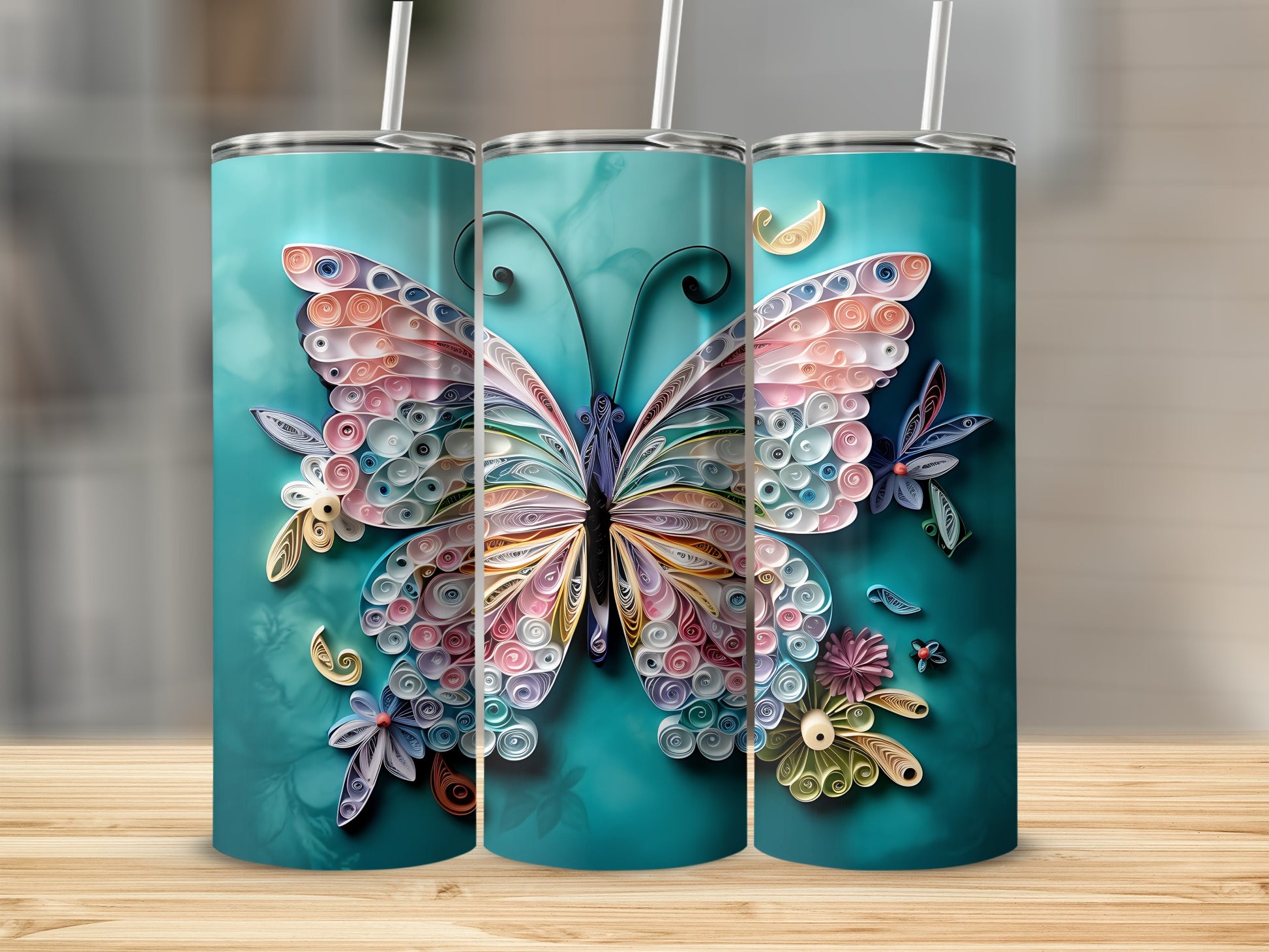 Three tumblers adorned with colorful quilled paper butterflies and flowers on a teal background.