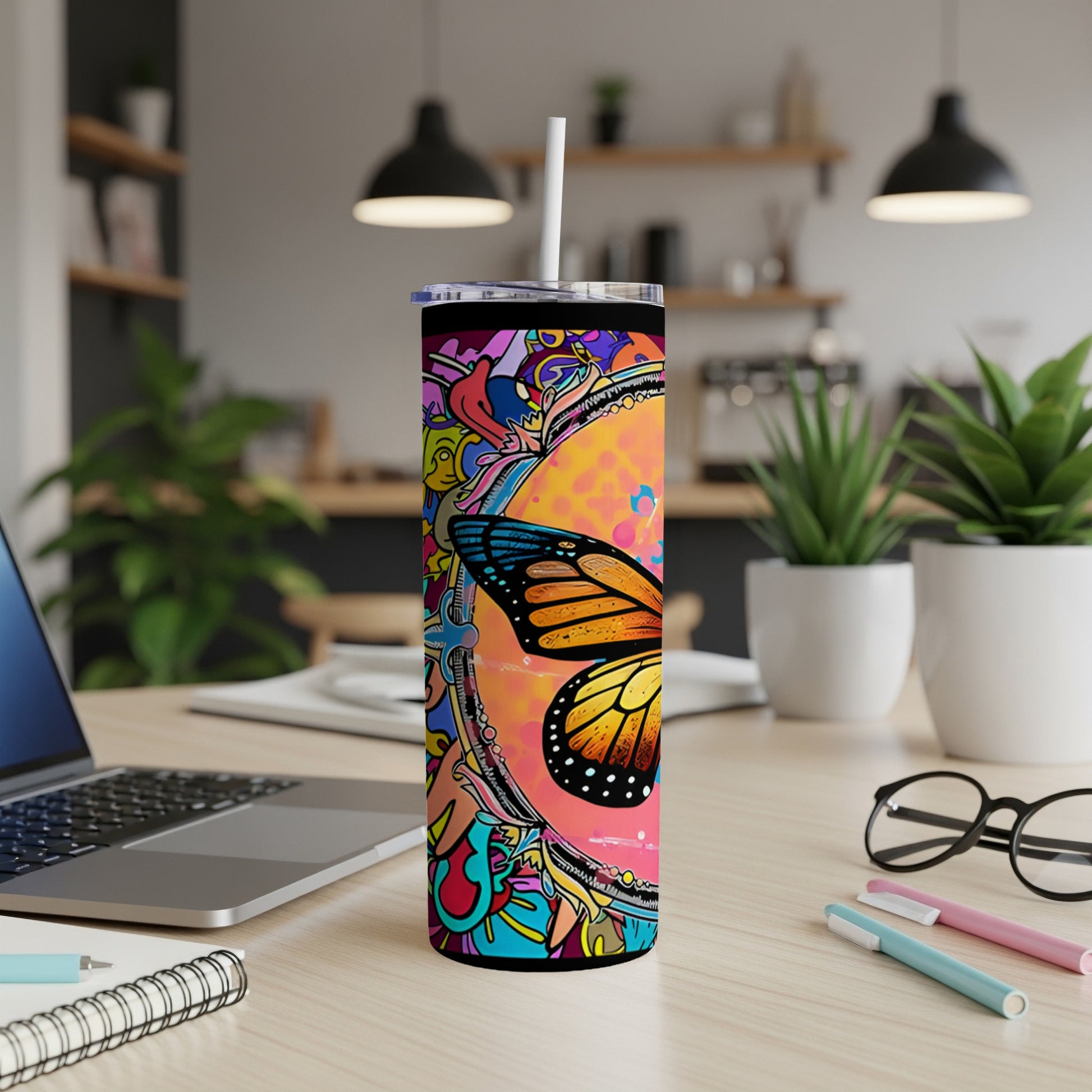Colorful butterfly tumbler with abstract art, on a desk.