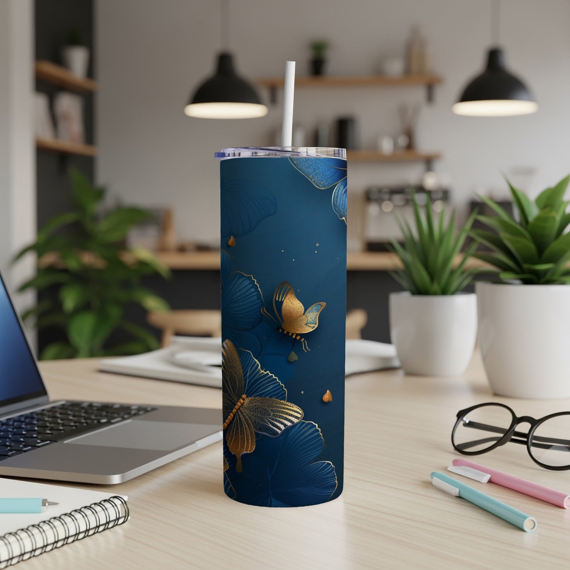 Navy blue tumbler with golden butterflies and leaves design.