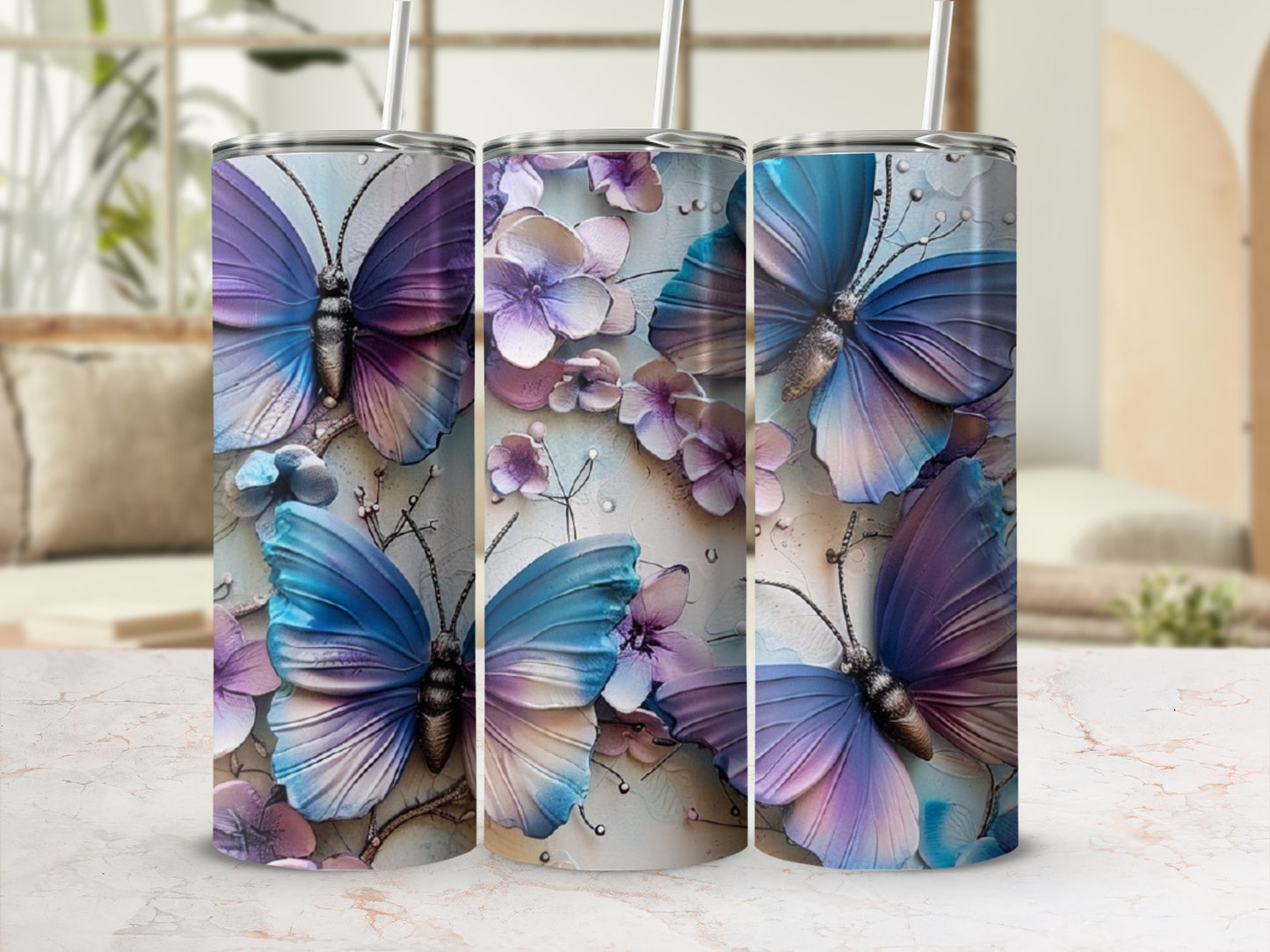 Three tumblers with purple and blue butterflies and floral designs.