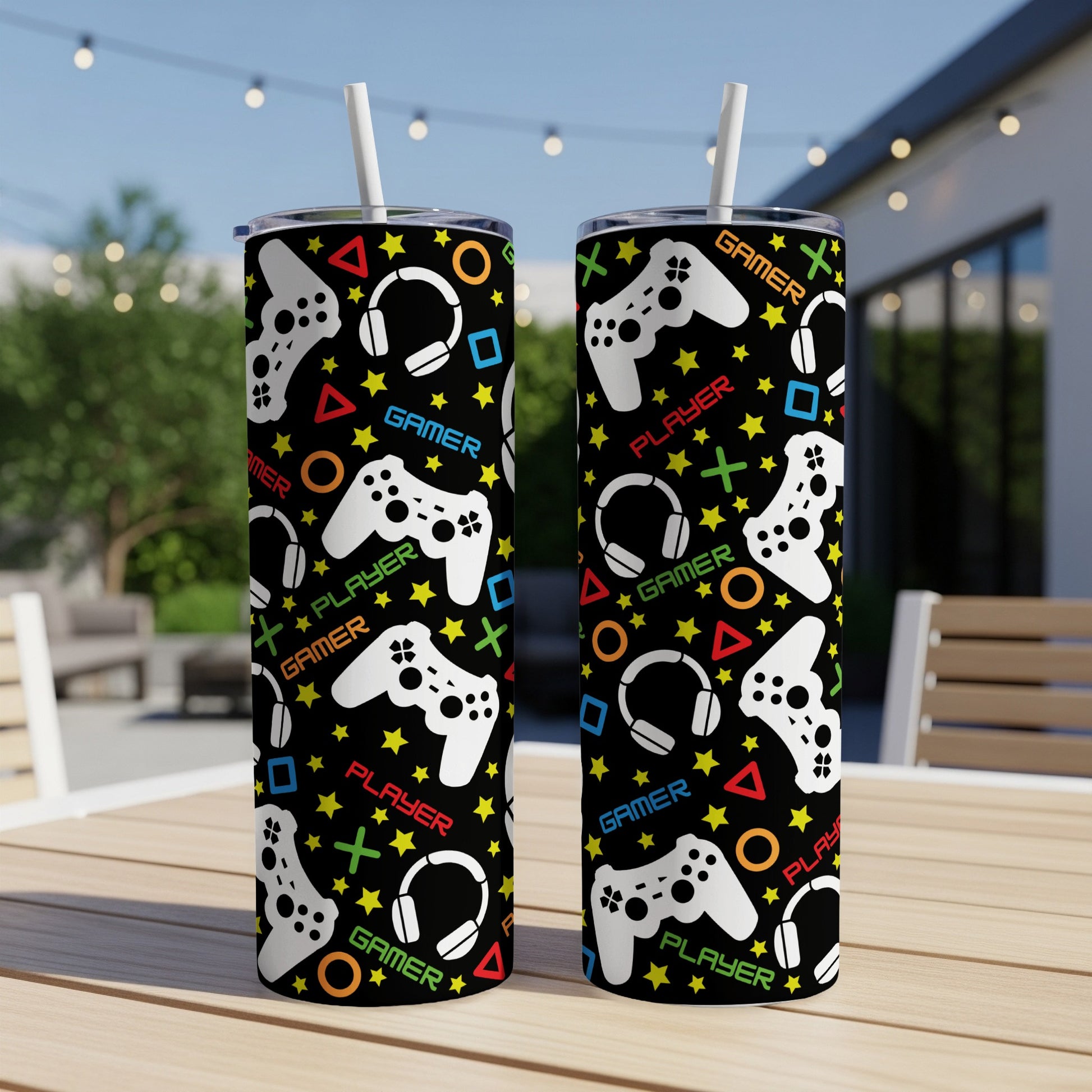 Two black tumblers with a repeating pattern of gaming controllers, headphones, and stars.