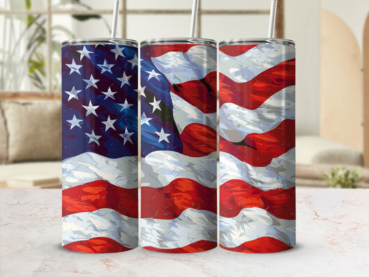 Three American flag tumblers with straws, angled and displayed on a white marble surface.