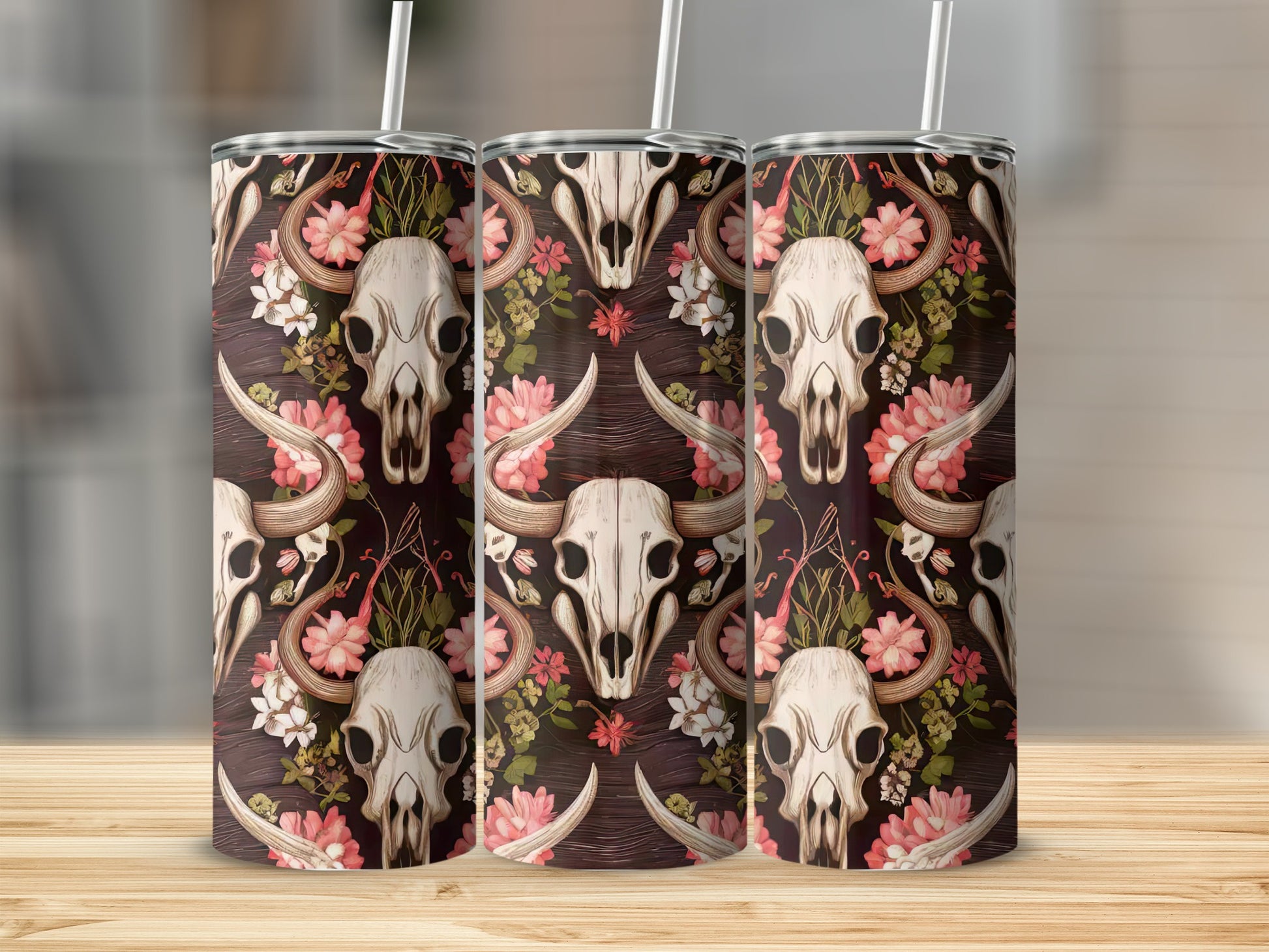 Three tumblers with floral cow skull pattern on wooden surface.
