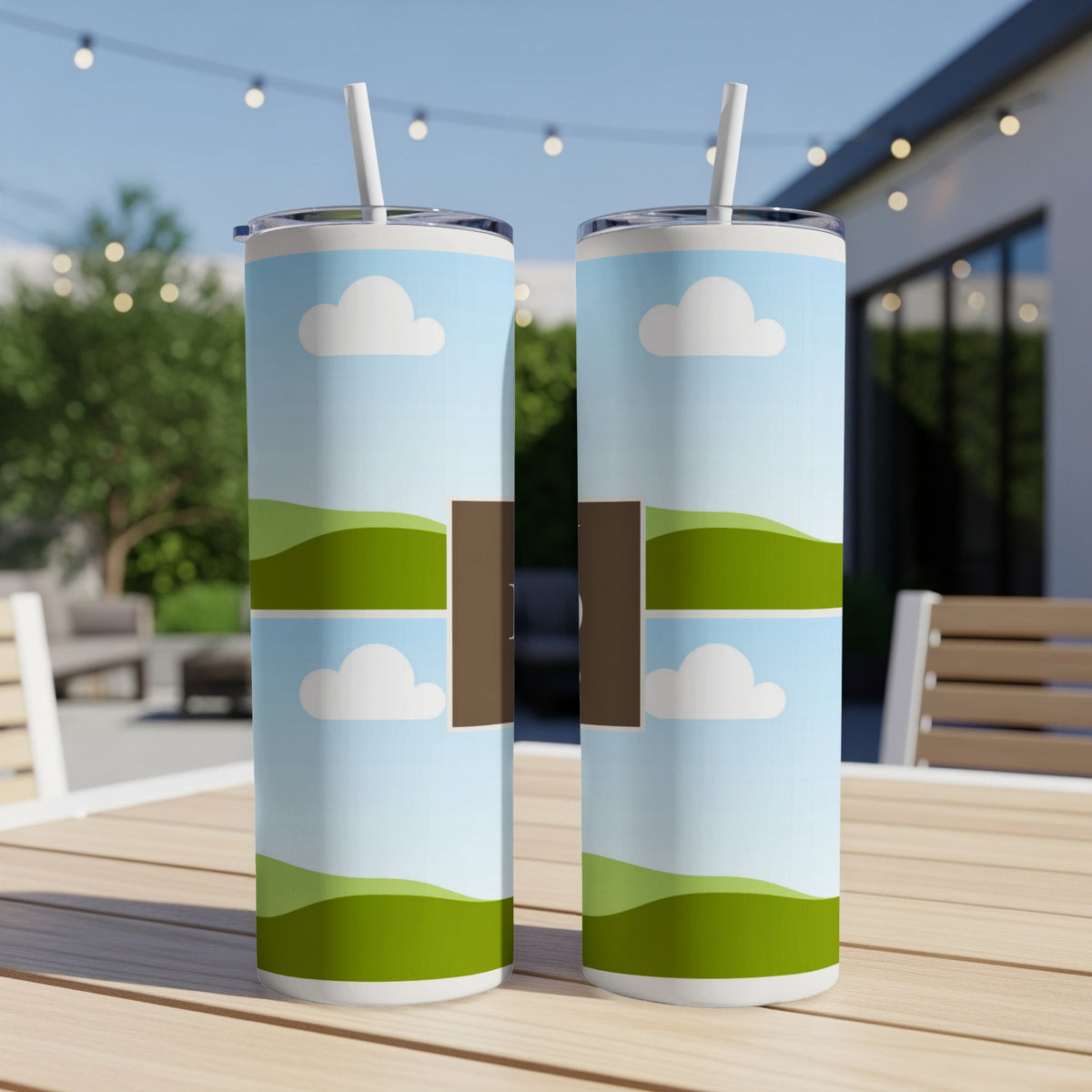 Two tumblers with clouds and rolling green hills design, shown outdoors.