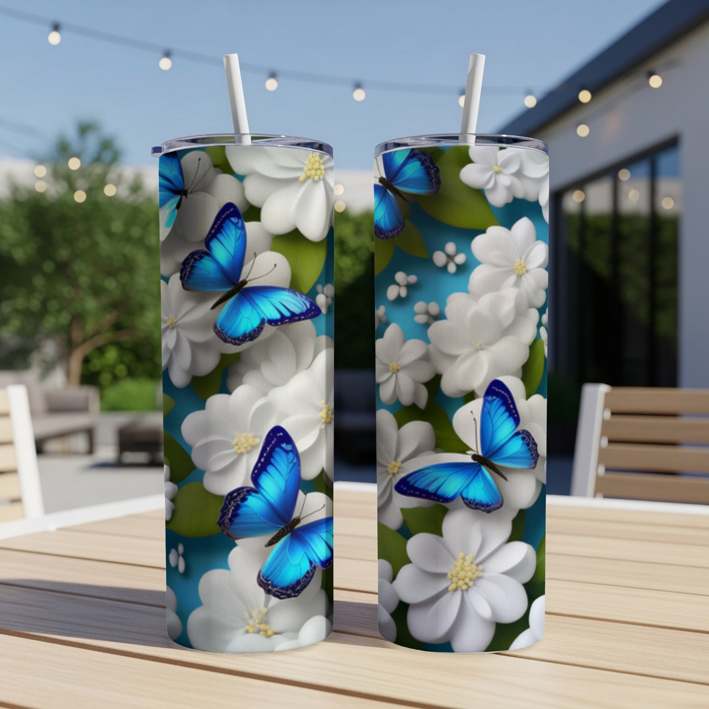 Two tall tumblers with blue butterflies and white flowers on a table.