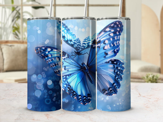 Three tumblers with vibrant blue butterflies and bokeh effect.