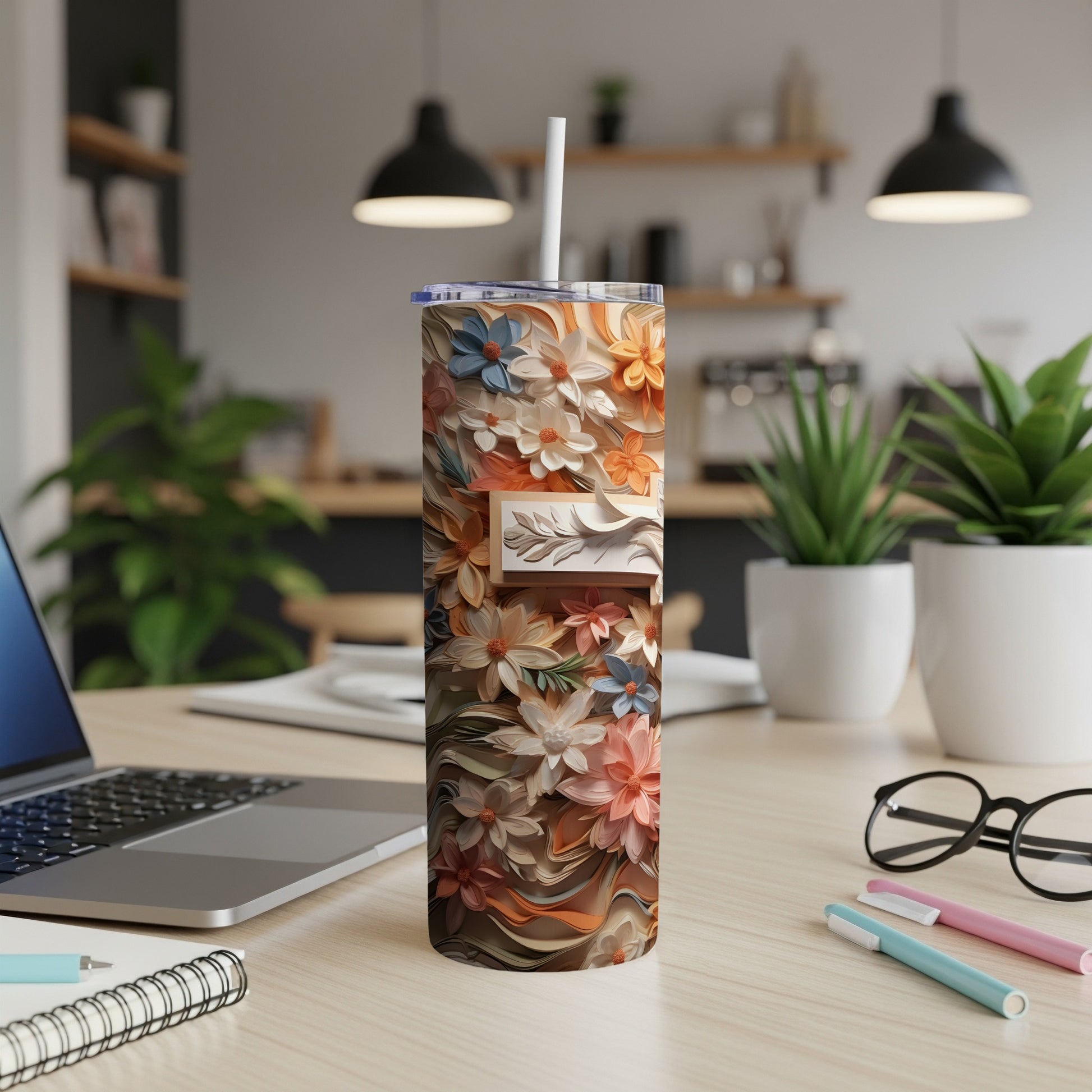 Floral patterned tumbler with a white straw on a wooden desk.