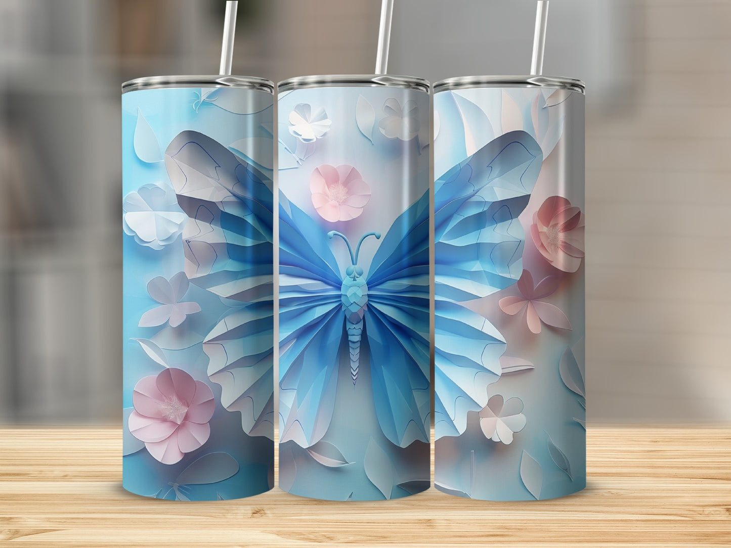 Three light blue tumblers with butterfly and floral papercraft designs.