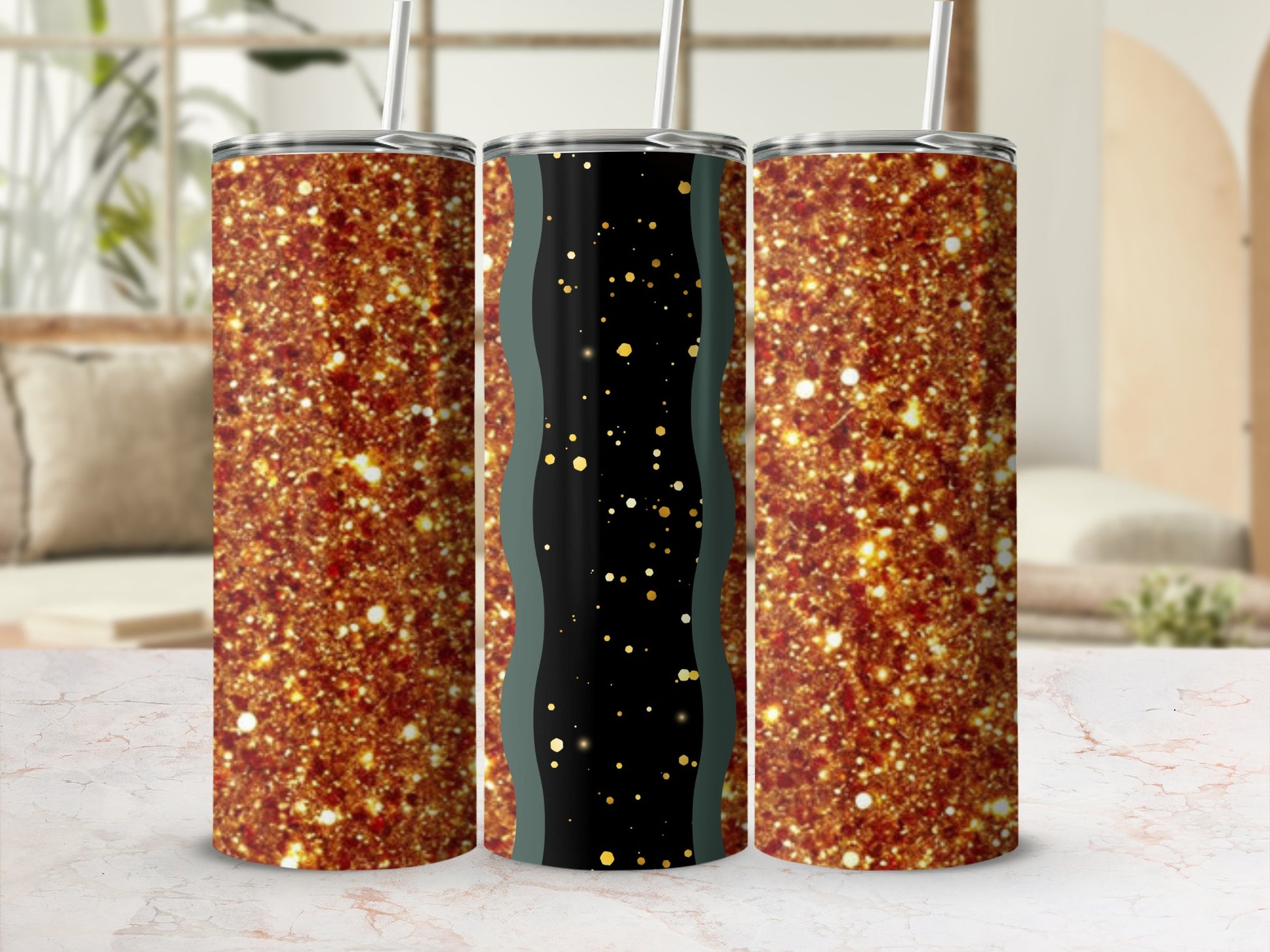 Three glittery tumblers with straws on a marble surface.