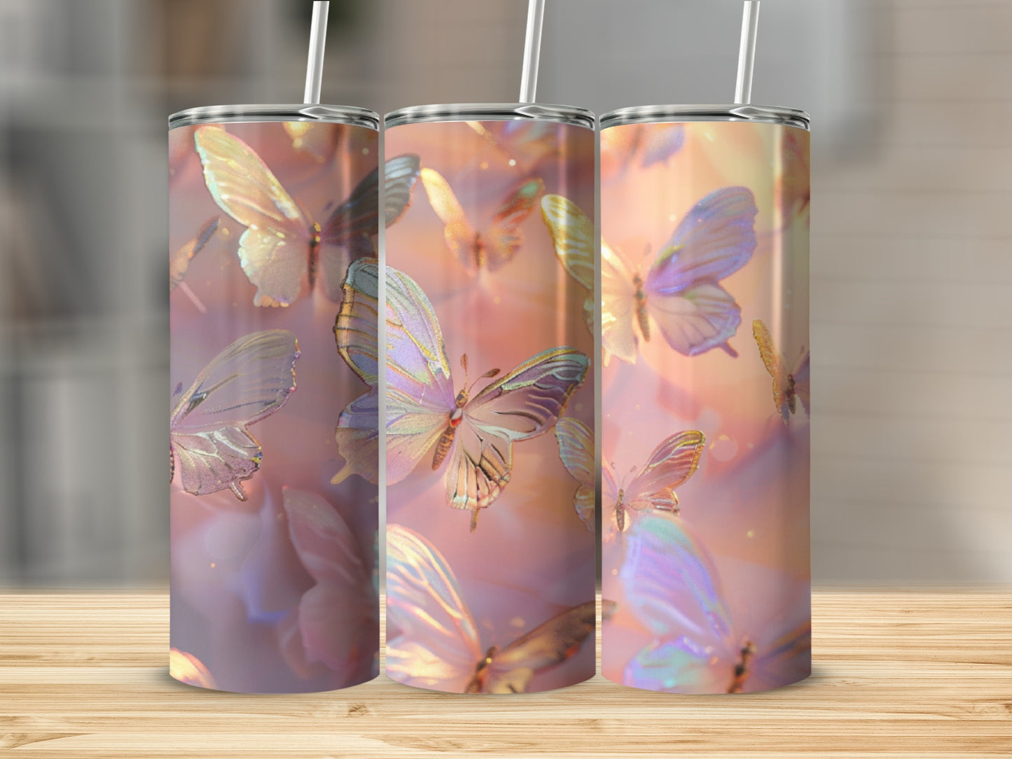 Three iridescent butterfly tumblers with straws on a wooden surface.