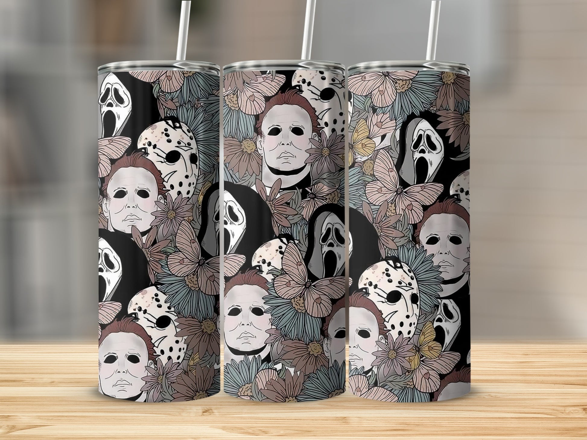 Three tumblers with horror movie mask designs and floral patterns.