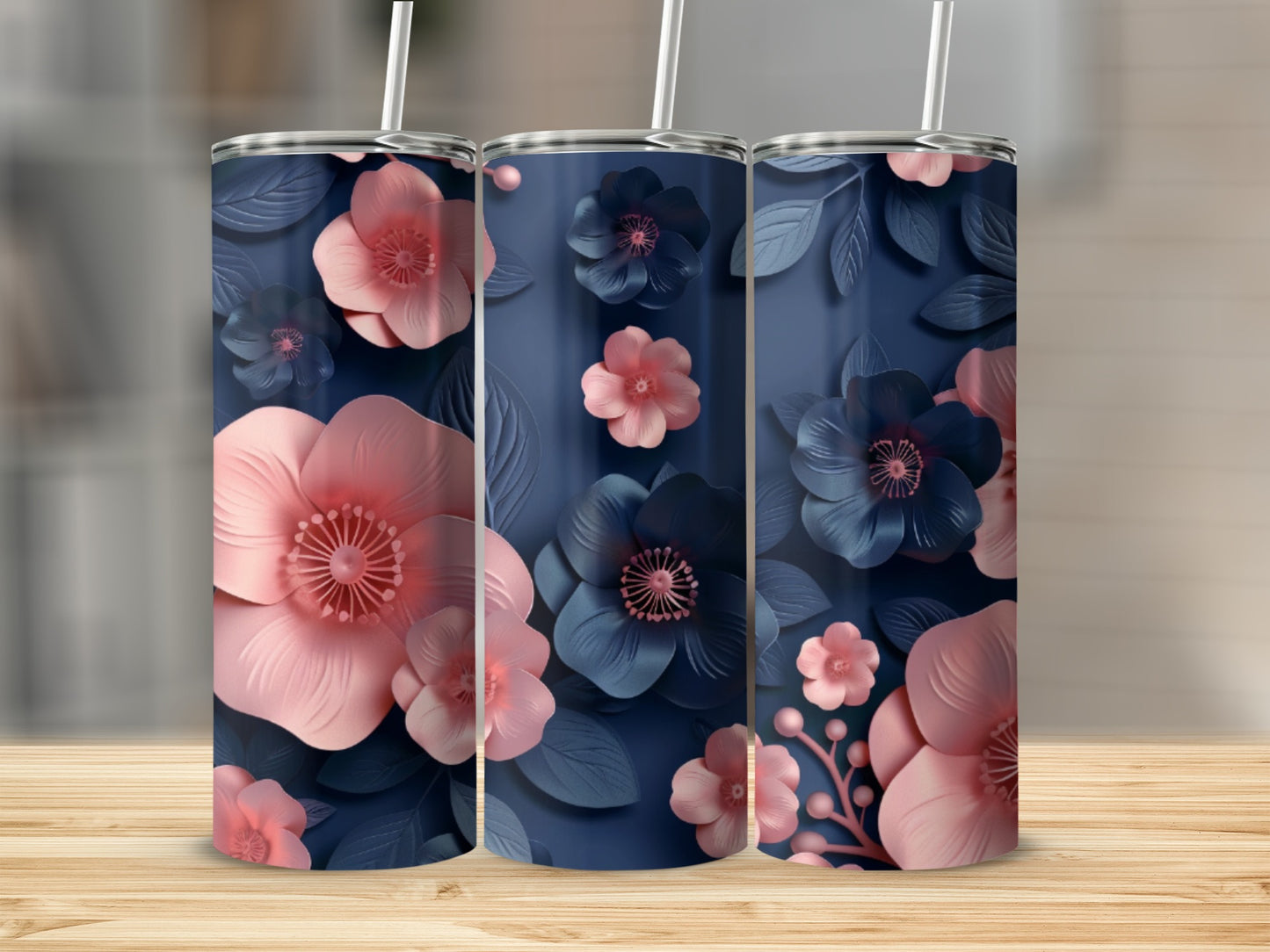 Three tall tumblers with a dark blue background and pink and blue floral designs.