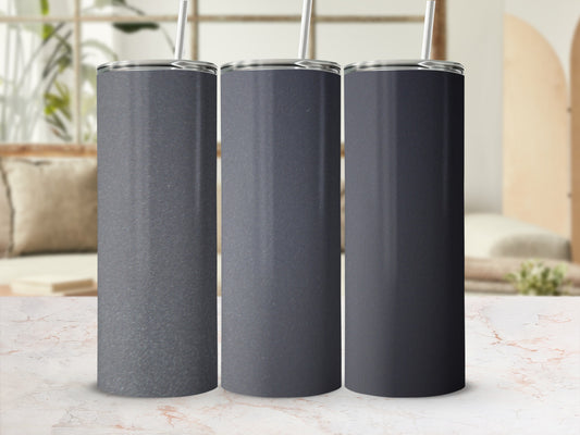 Three dark gray tumblers with straws on a marble surface.