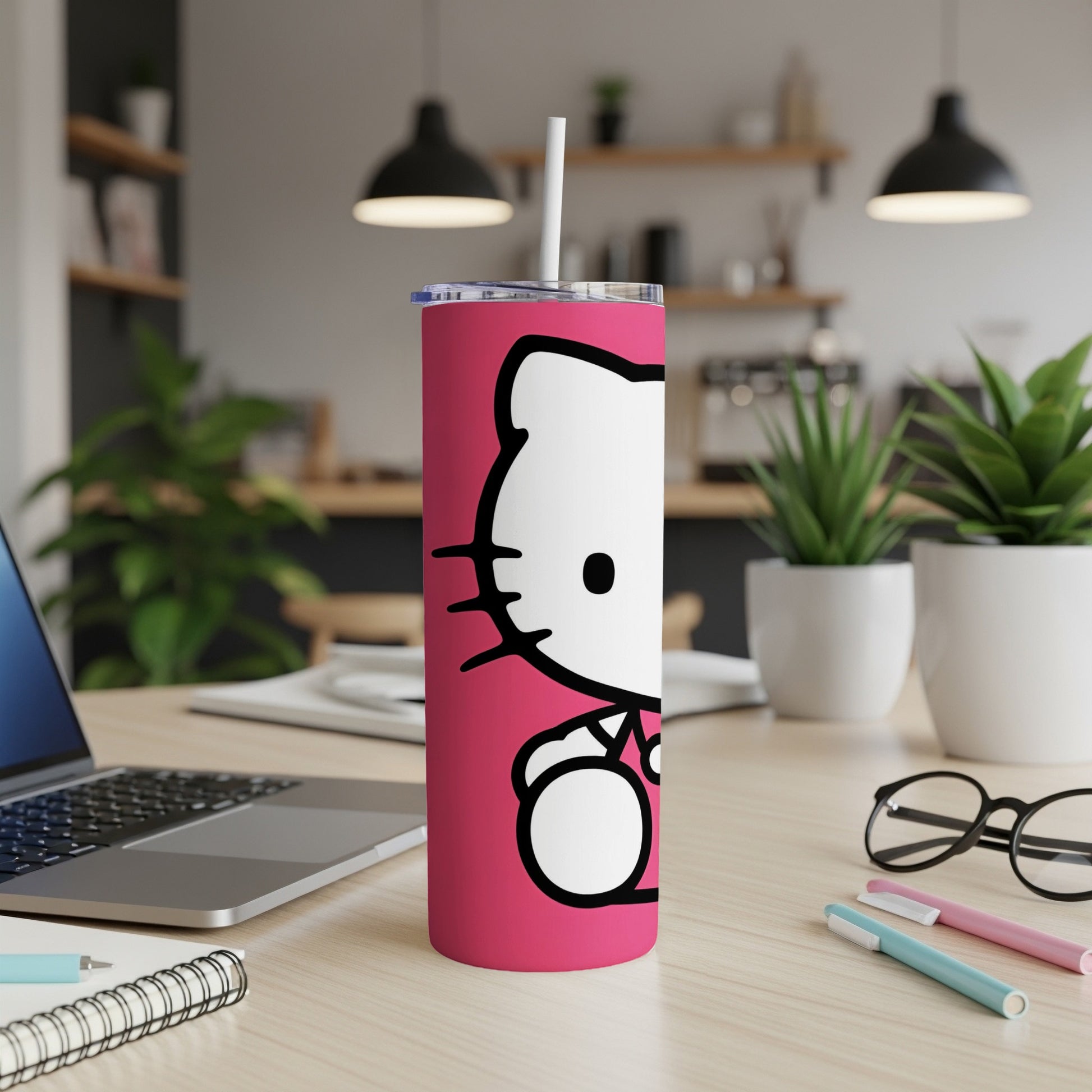 Pink Hello Kitty tumbler with white straw on a wooden desk.