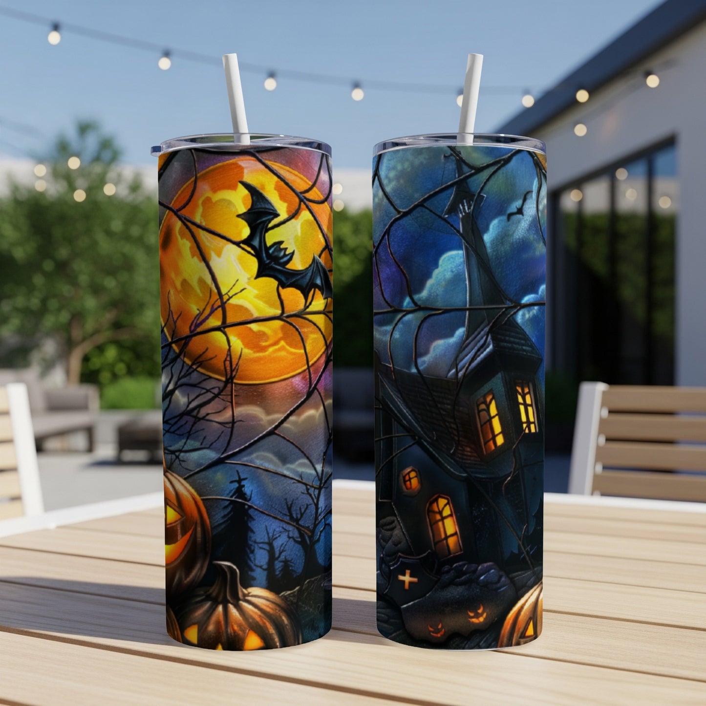 Two Halloween tumblers featuring a haunted house and pumpkins under a moonlit sky.