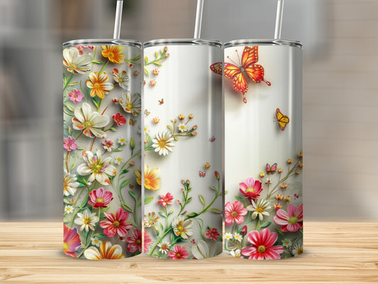 Three tumblers with floral and butterfly designs on a wooden surface.