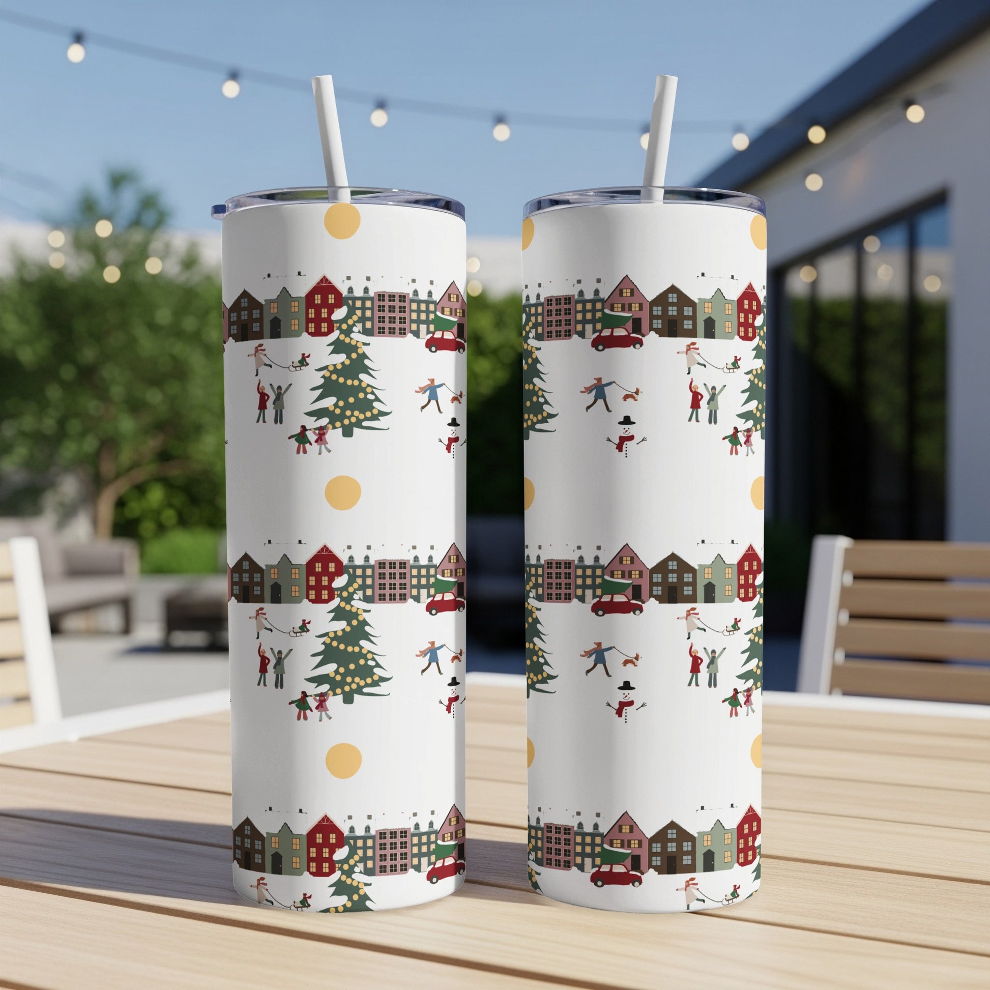 White tumbler with a repeating Christmas village pattern of houses, trees, and snowmen.