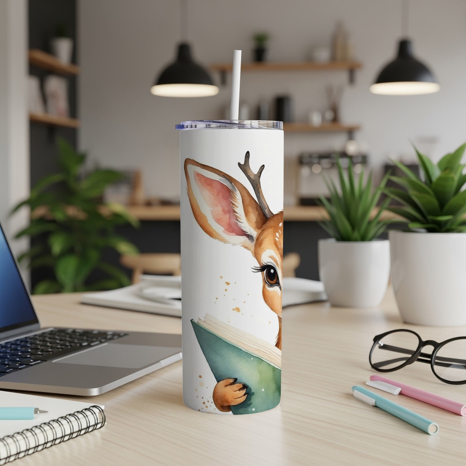 Watercolor illustration of a deer reading a book on a white tumbler.