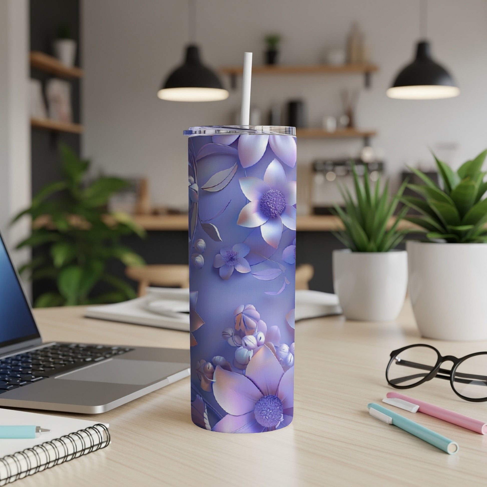 Purple floral tumbler with straw on a wooden desk.