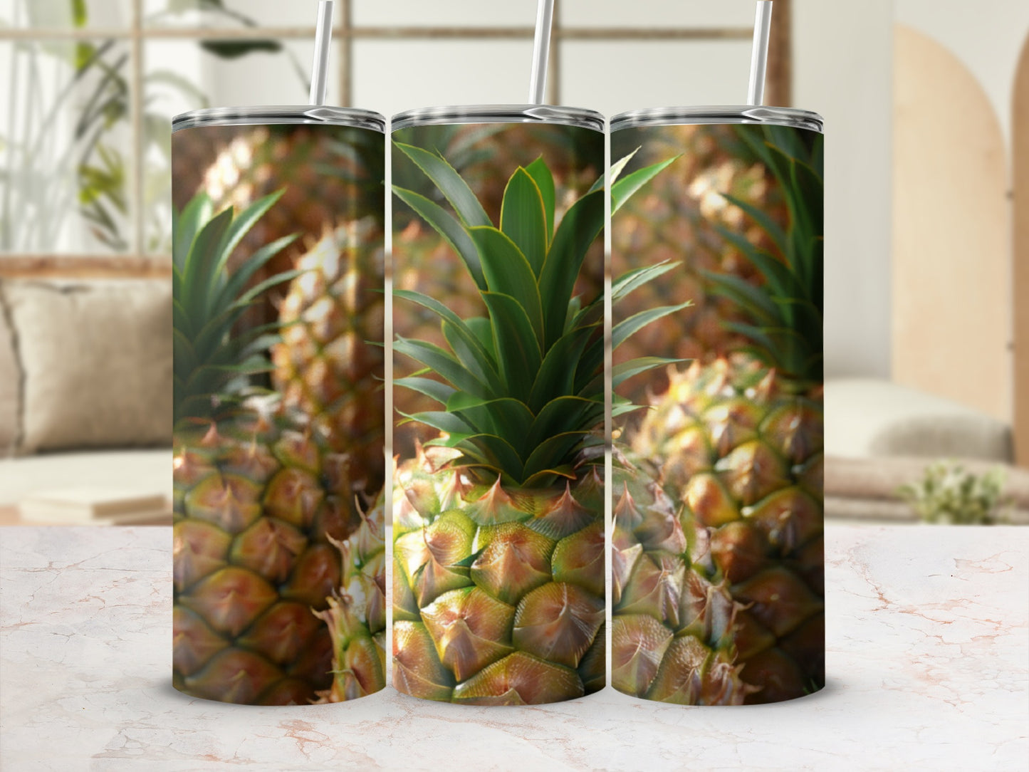 Three tumblers with a pineapple print, on a marble surface.