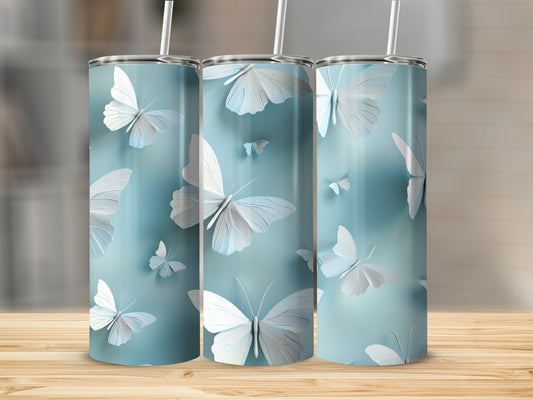 Three light blue tumblers with white butterfly designs on a wooden surface.
