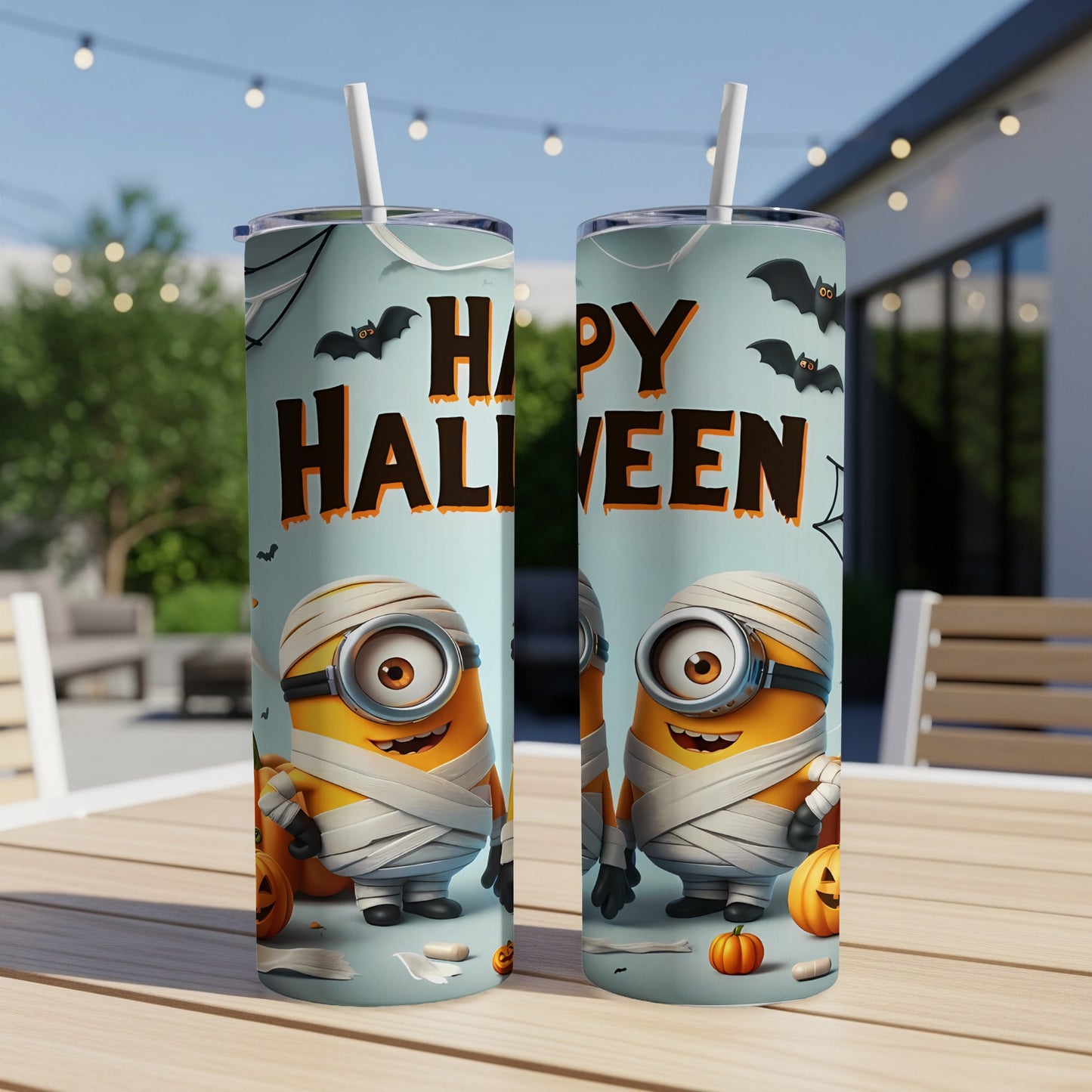 Two Minions dressed as mummies with pumpkins and bats on a Happy Halloween tumbler.