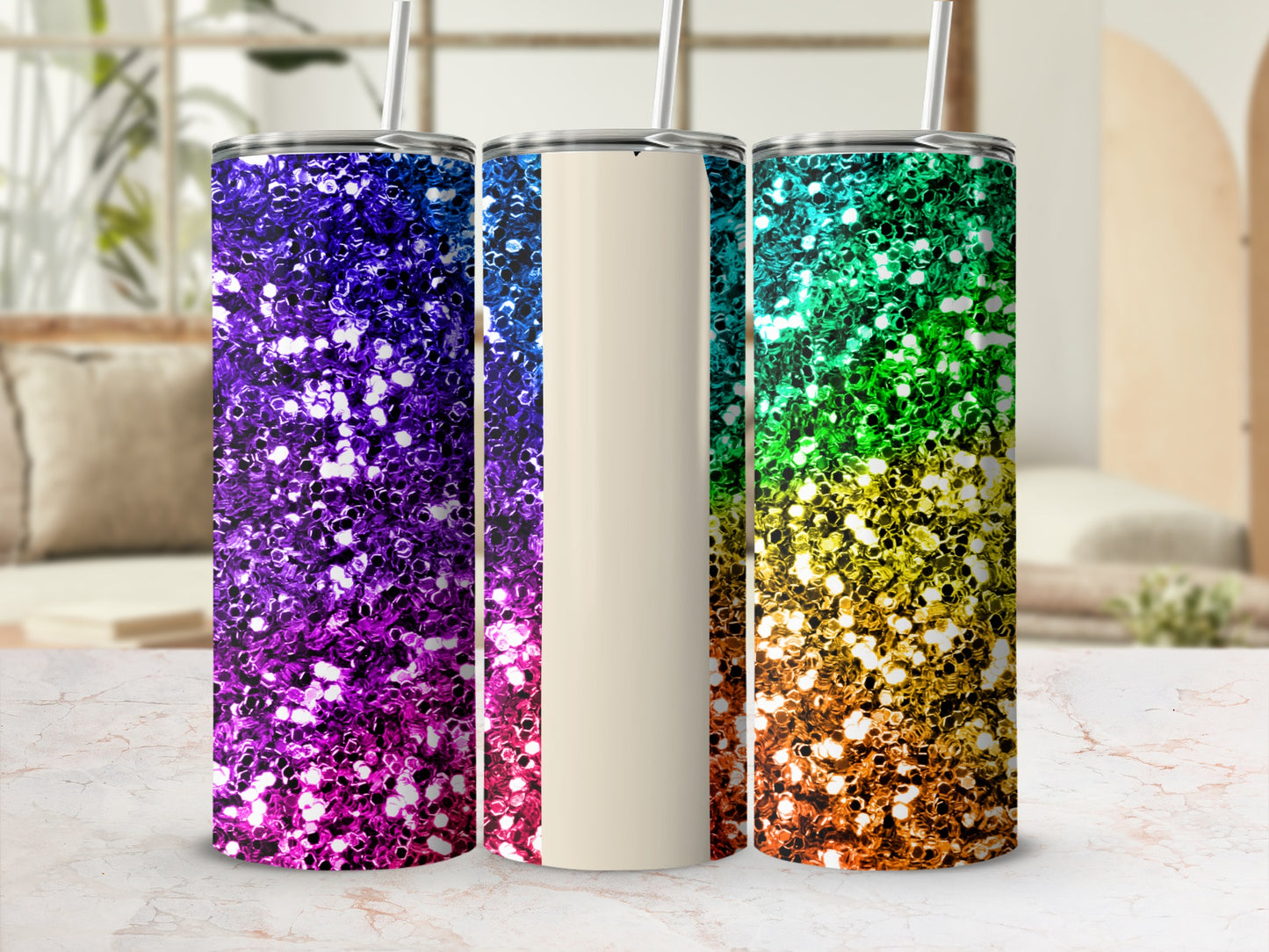 Three glittery tumblers in rainbow gradient colors on a marble surface.