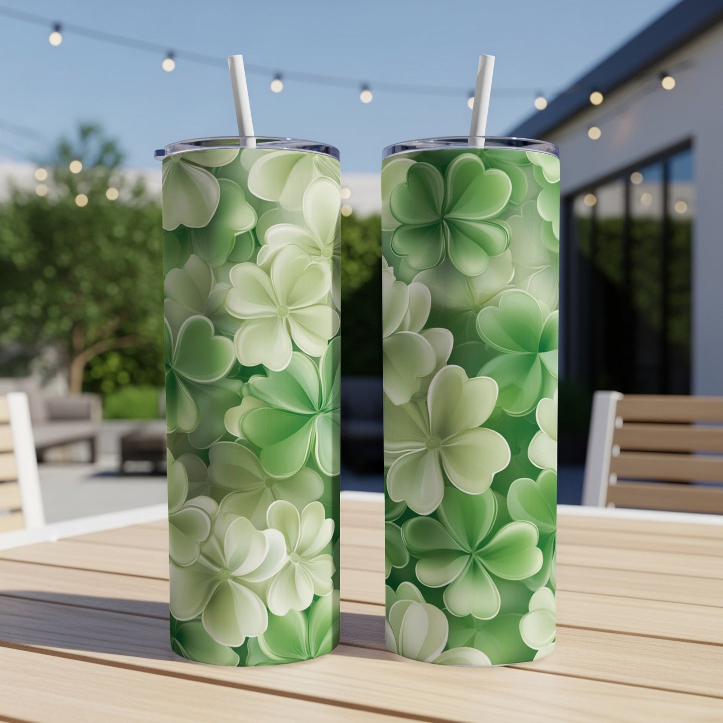 Two green shamrock patterned tumblers with straws on a table.