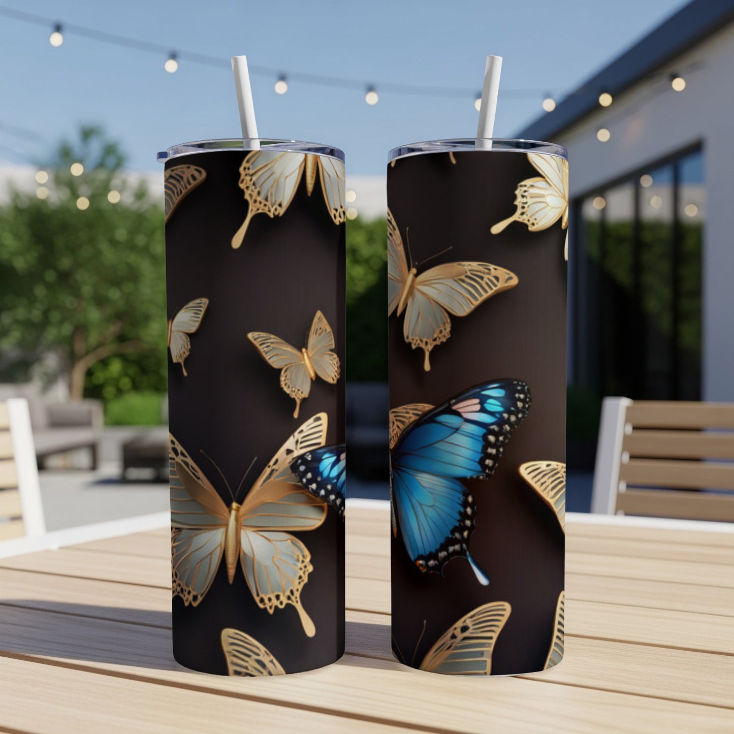 Two tumblers with a gold and blue butterfly pattern on a dark background.