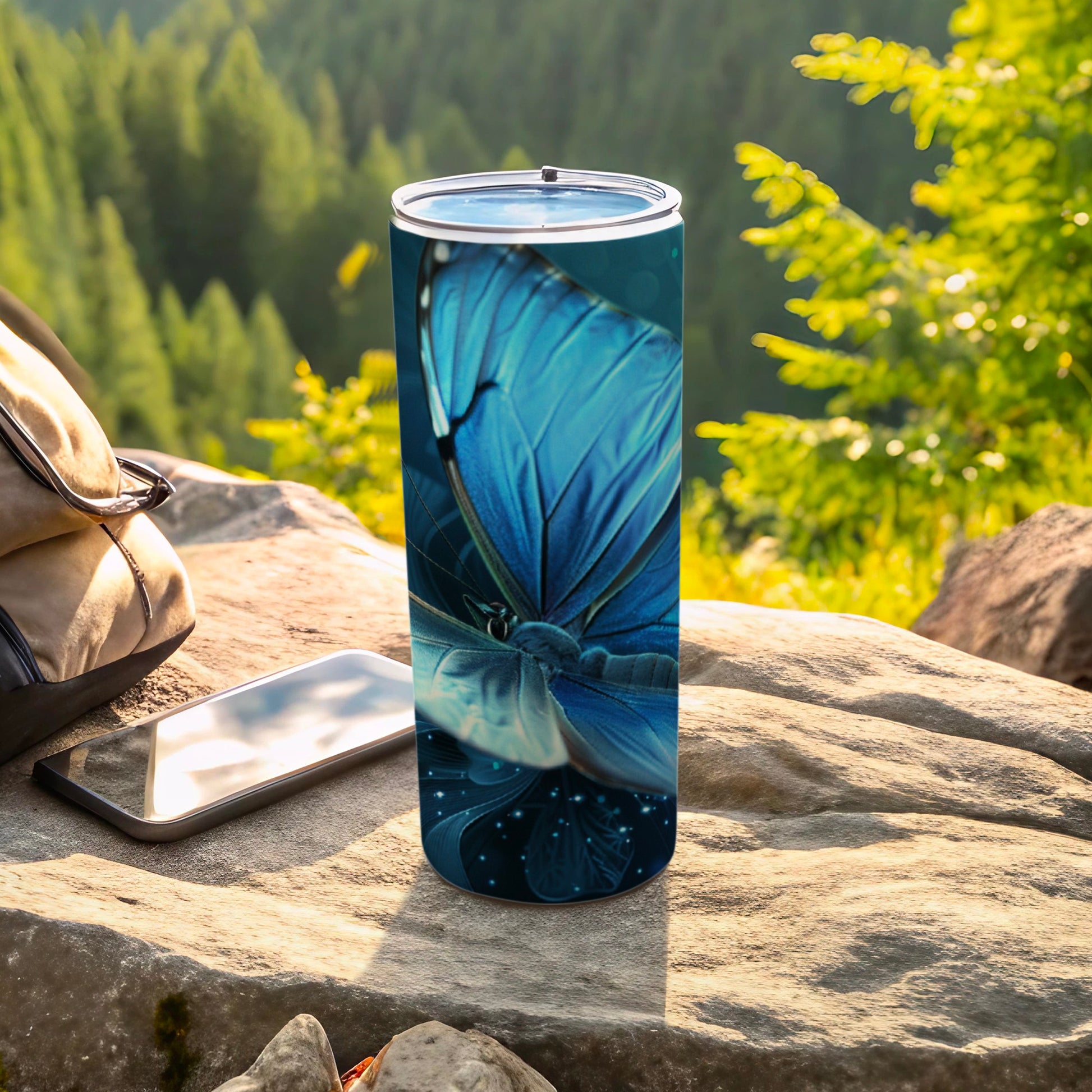 Blue butterfly on a blue speckled tumbler with a phone and backpack.