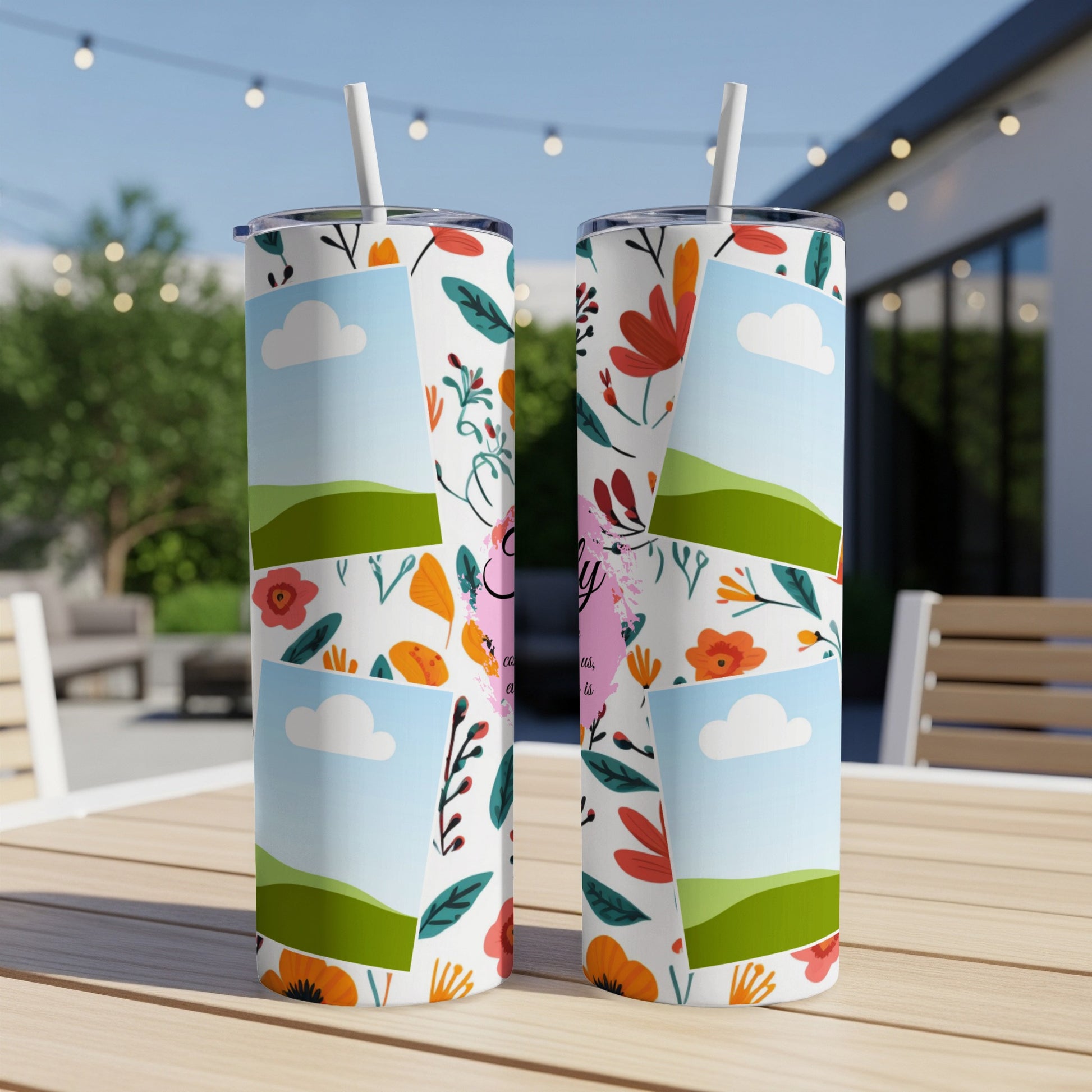 Two tumblers with a floral pattern and photo frames sit on a table outdoors.