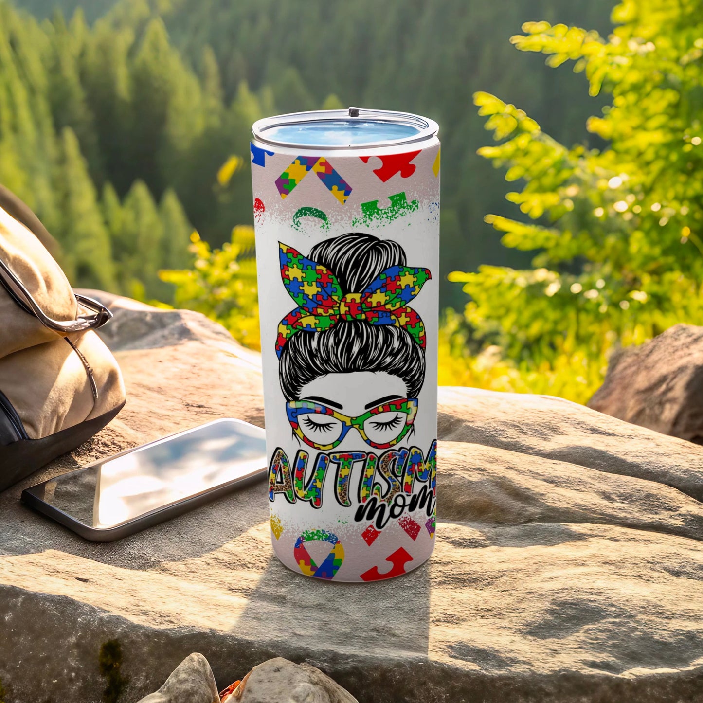 Autism Mom tumbler with colorful puzzle piece bow and glitter.
