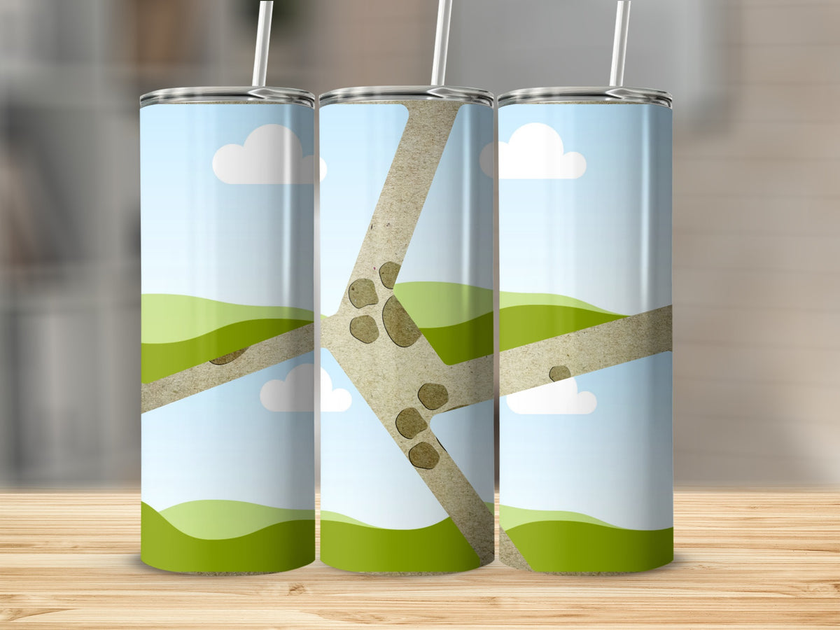 Three tumblers with a cartoon landscape design of green hills and clouds.