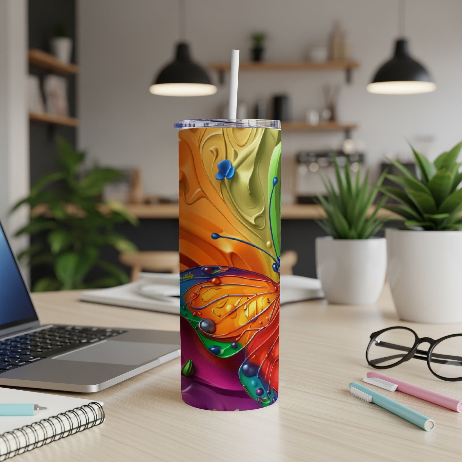 Tumbler with a colorful butterfly design on a desk.