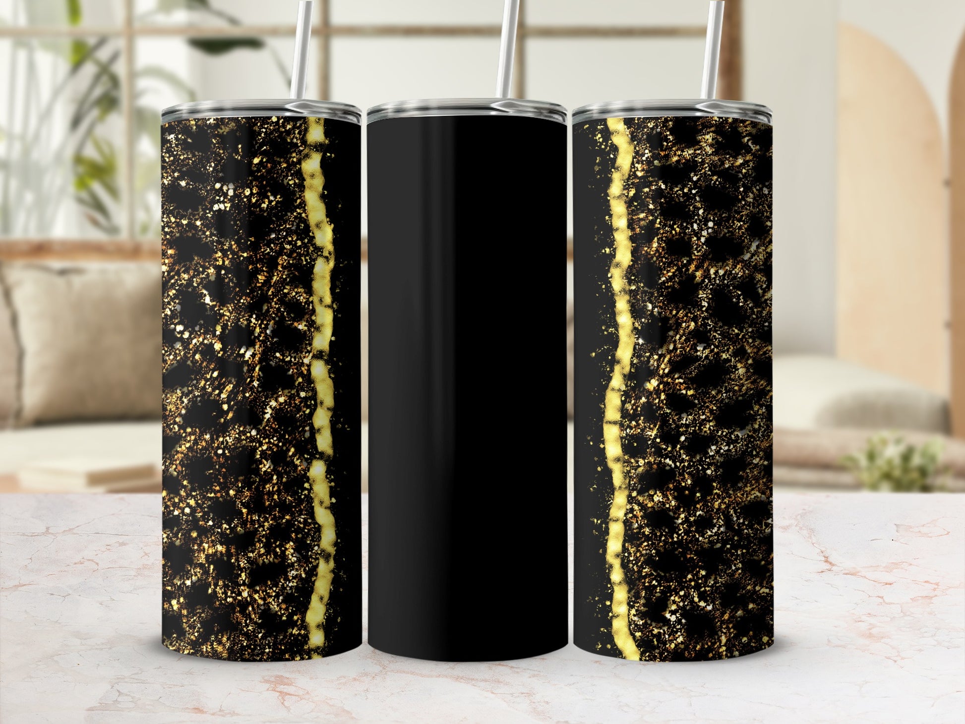 Black tumbler with sparkly gold accents on marble surface.