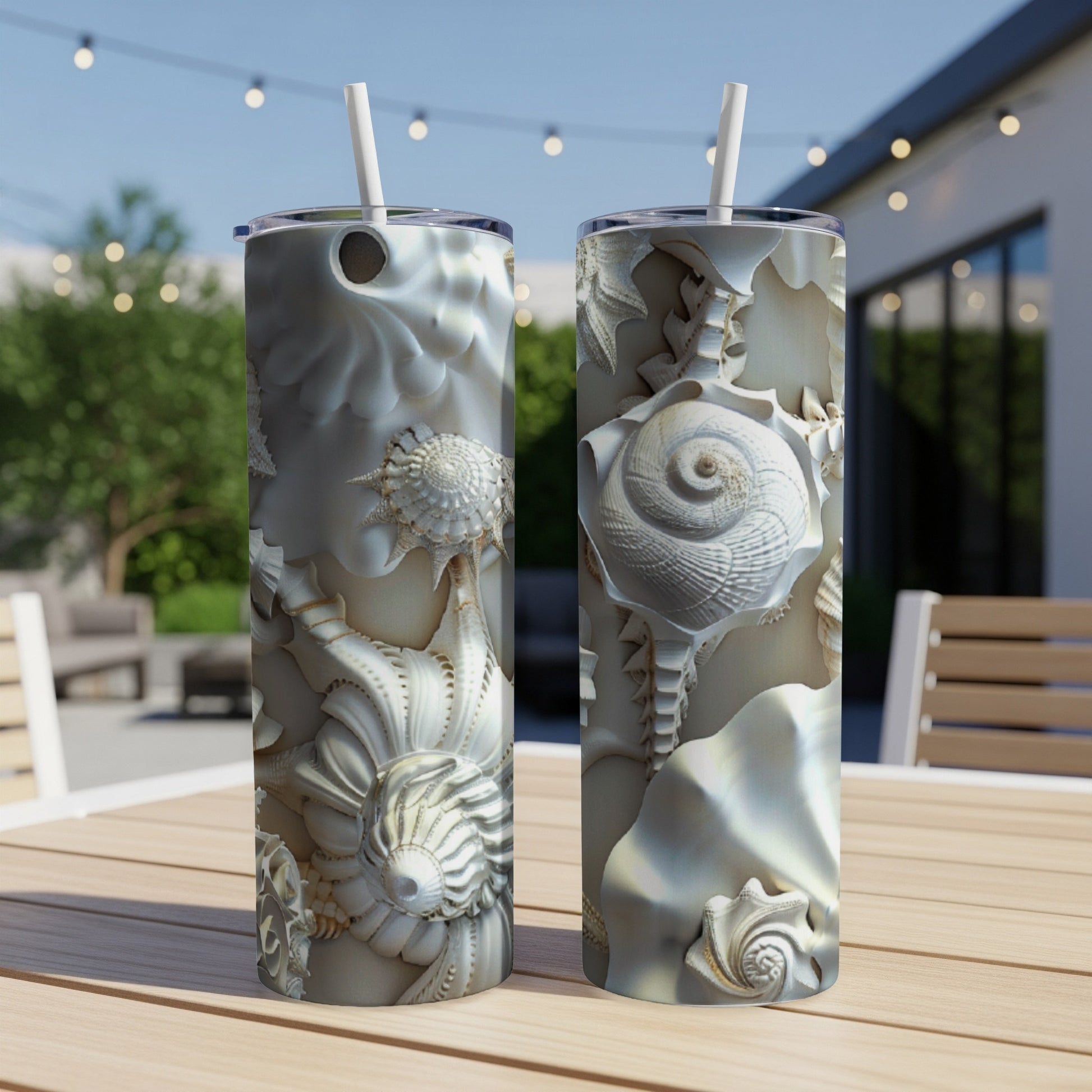 Two tall tumblers with intricate seashell patterns on a wooden table.