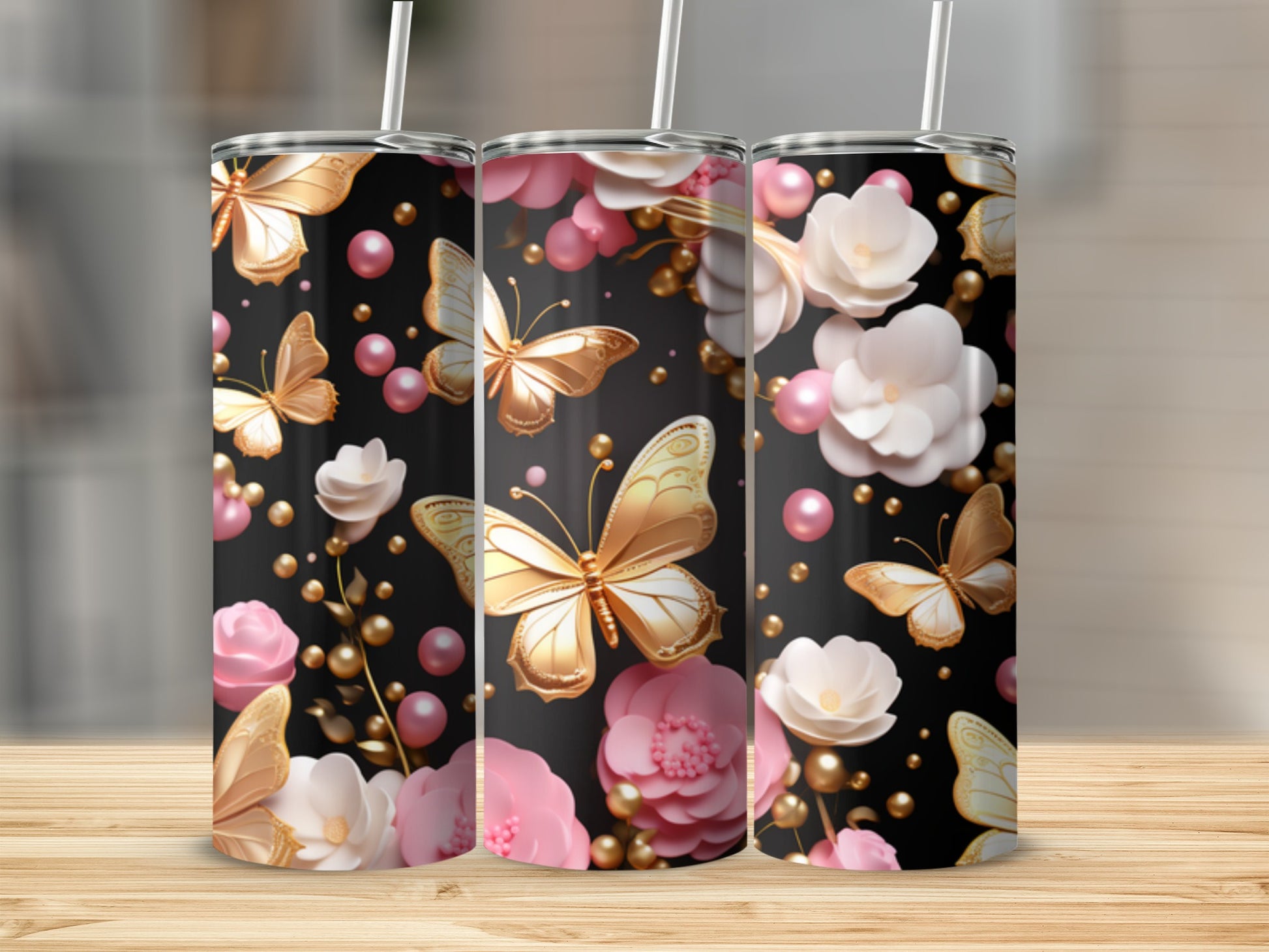 Three tumblers with golden butterflies and pink flowers on a black background.