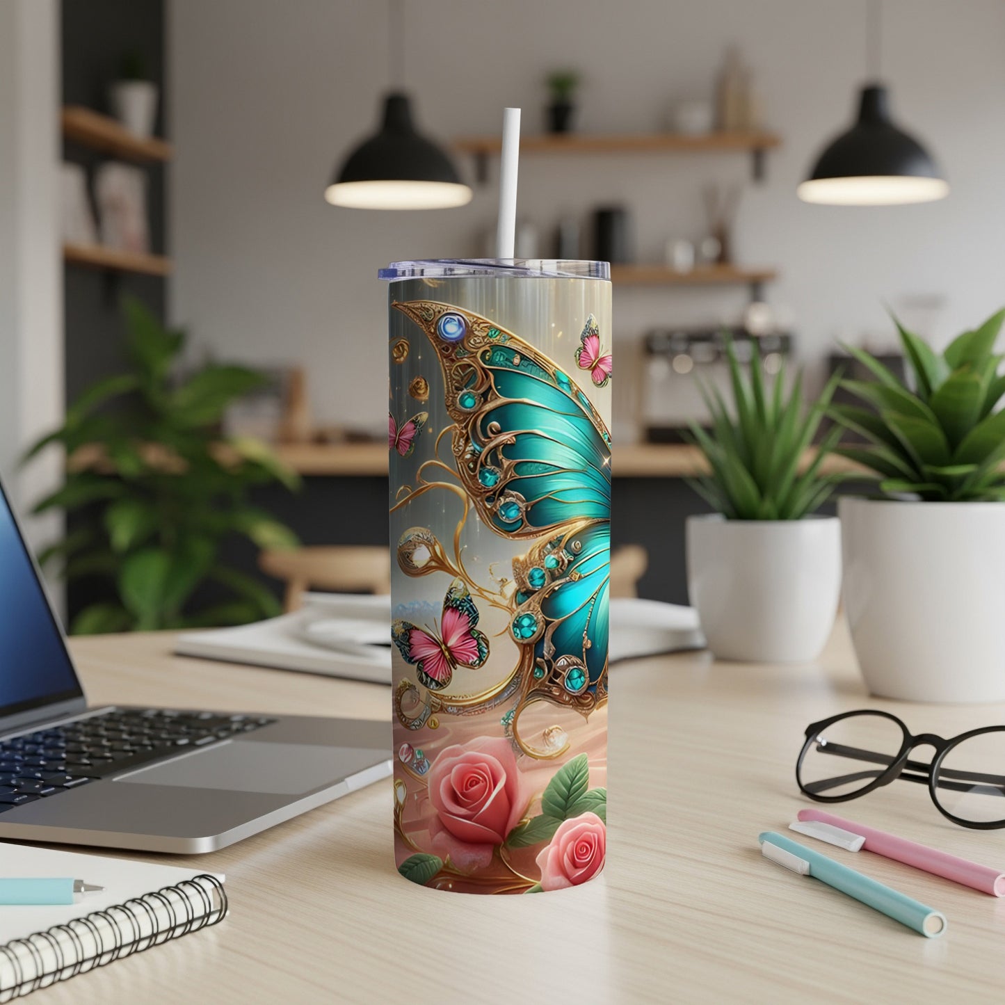 Butterfly and rose patterned tumbler with straw on desk.