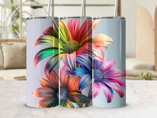 Three tumblers with vibrant, abstract floral designs and straws.